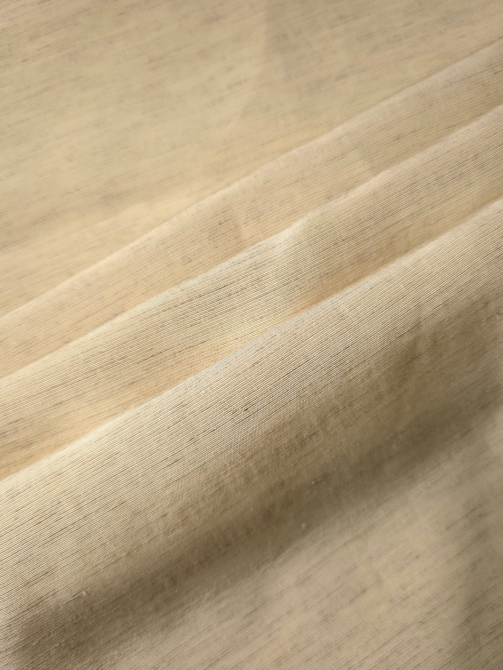 Texture view of soft cream linen viscose plain fabric highlighting its flowy, breathable finish.