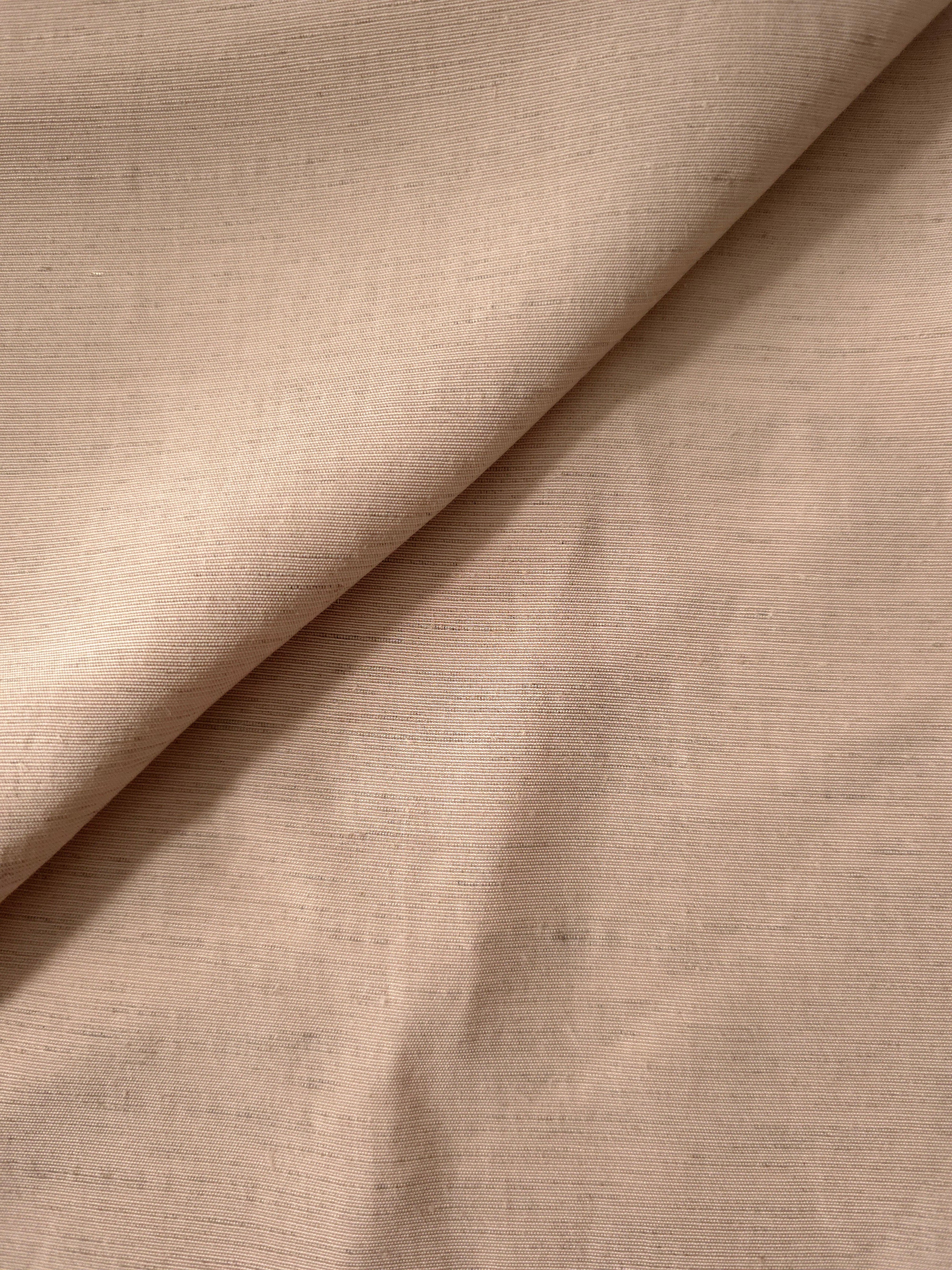 Close-up of warm sandy beige linen viscose plain fabric showing its natural woven texture.