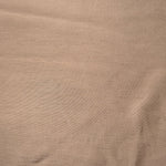 Warm sandy beige linen viscose plain fabric draped to show its soft structure, ideal for dressmaking.