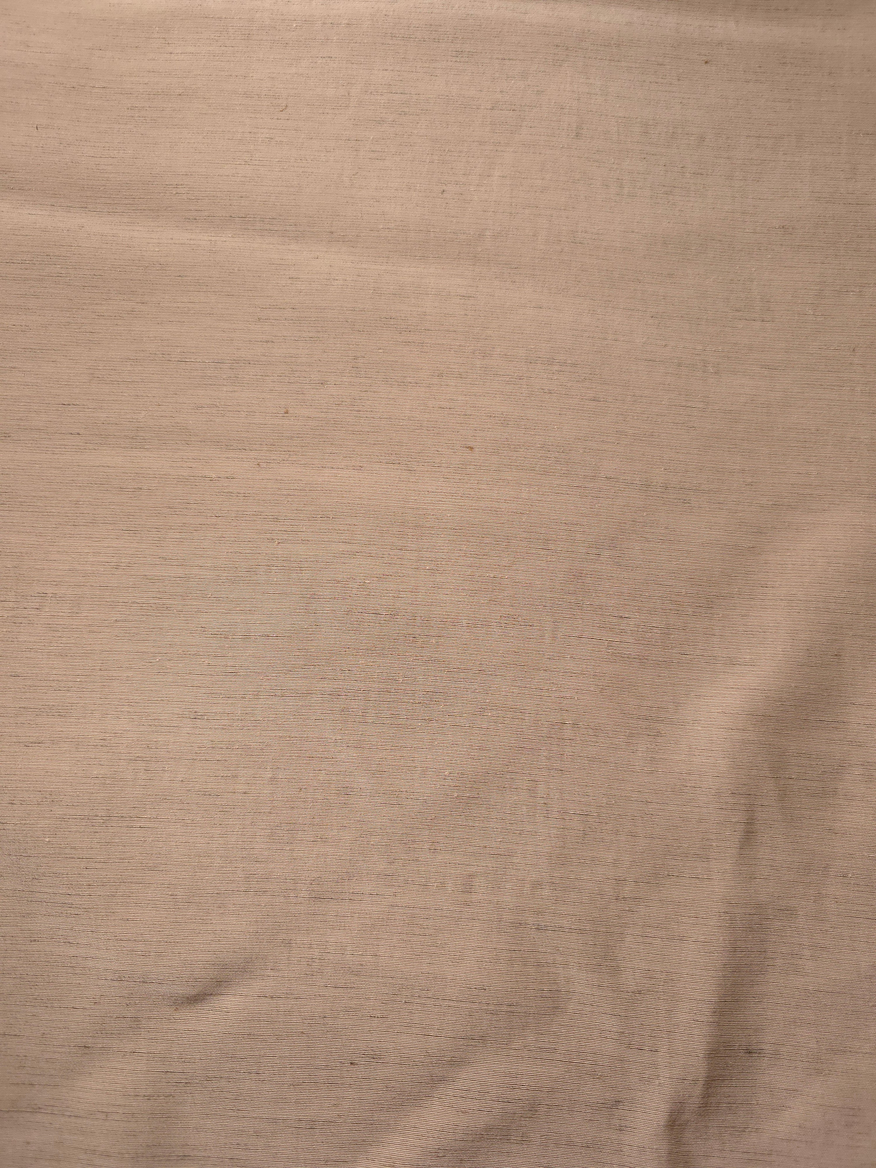 Warm sandy beige linen viscose plain fabric draped to show its soft structure, ideal for dressmaking.