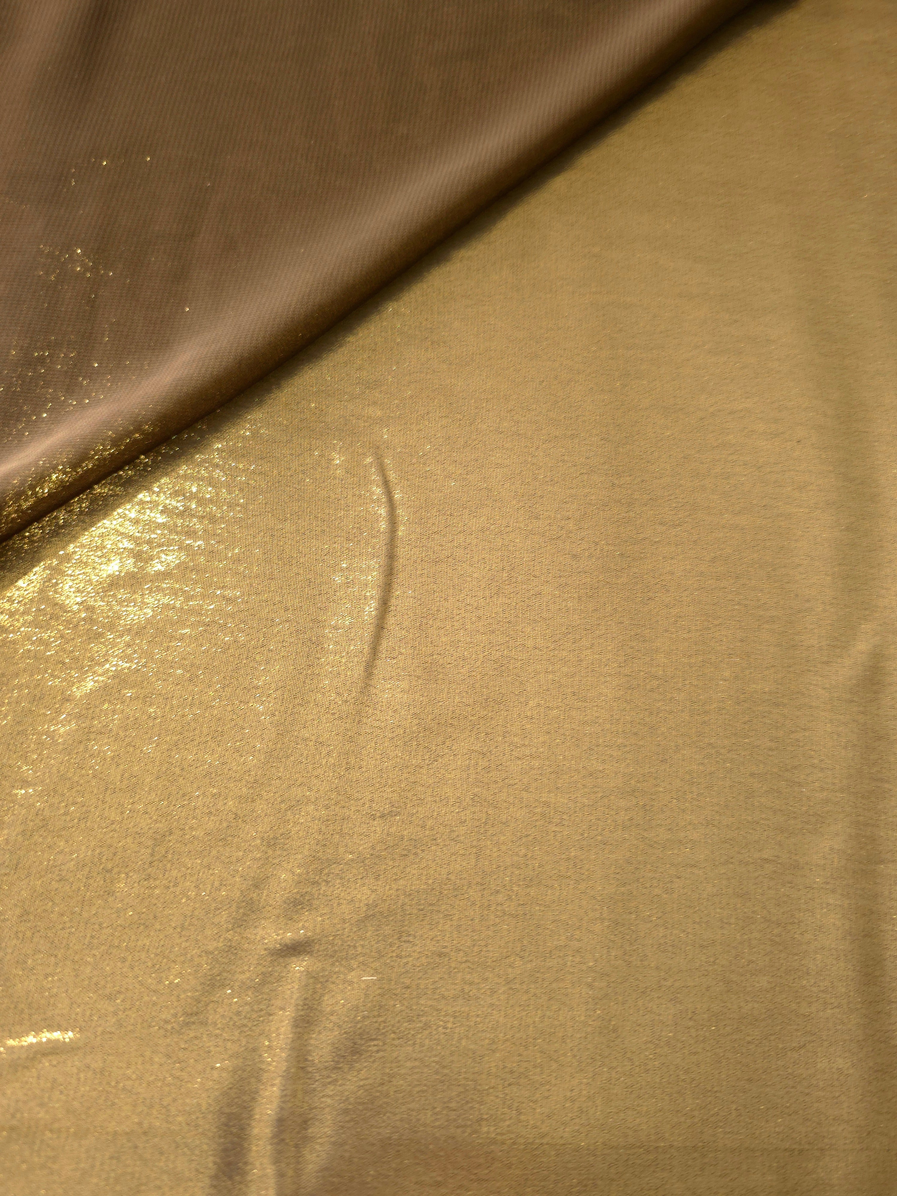 Antique gold soft draping view of liquid metallic shimmer chiffon fabric, highlighting fluid folds and reflective surface