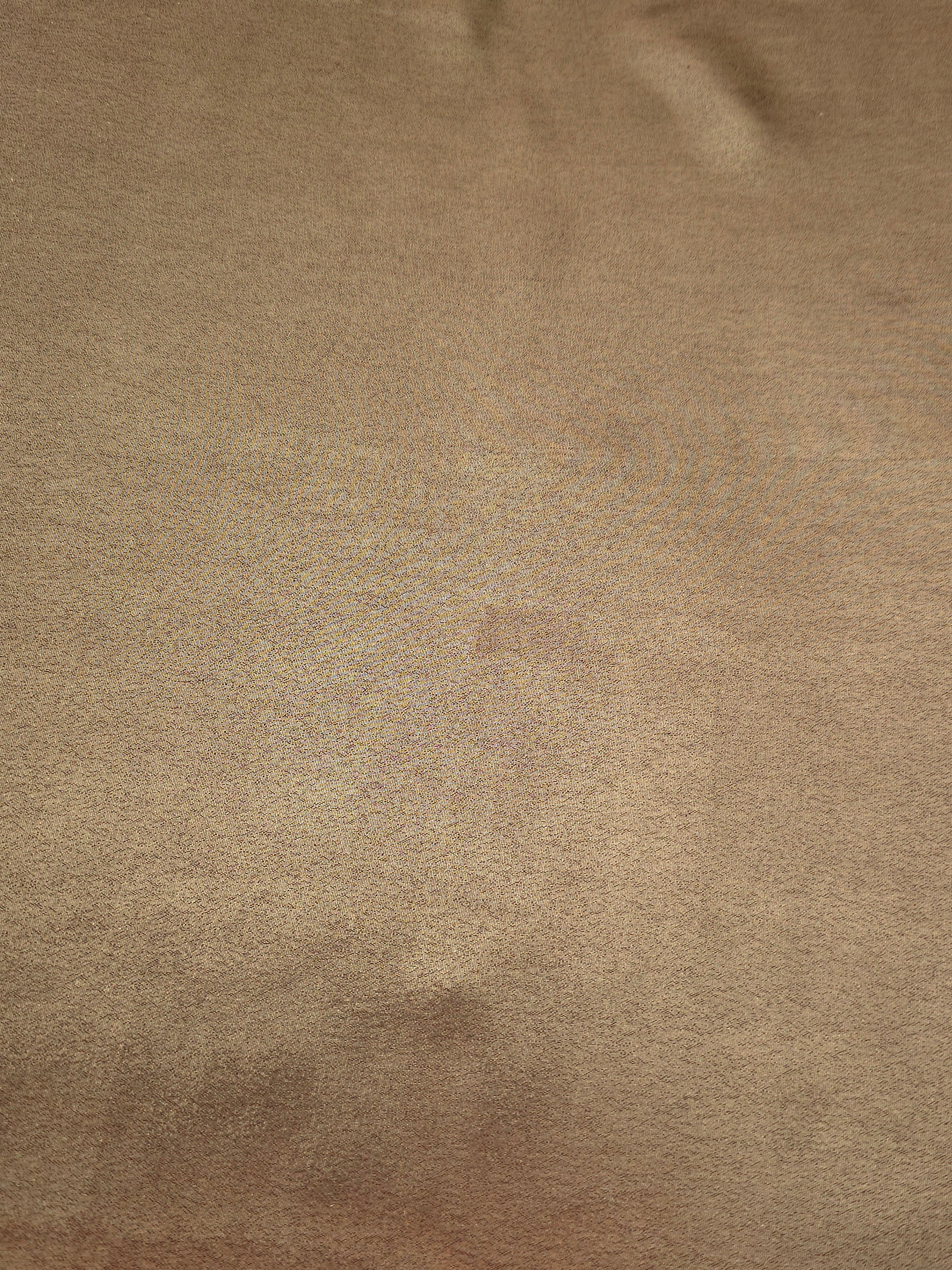 Copper glow fold detail view of liquid metallic shimmer chiffon fabric, highlighting fluid folds and reflective surface