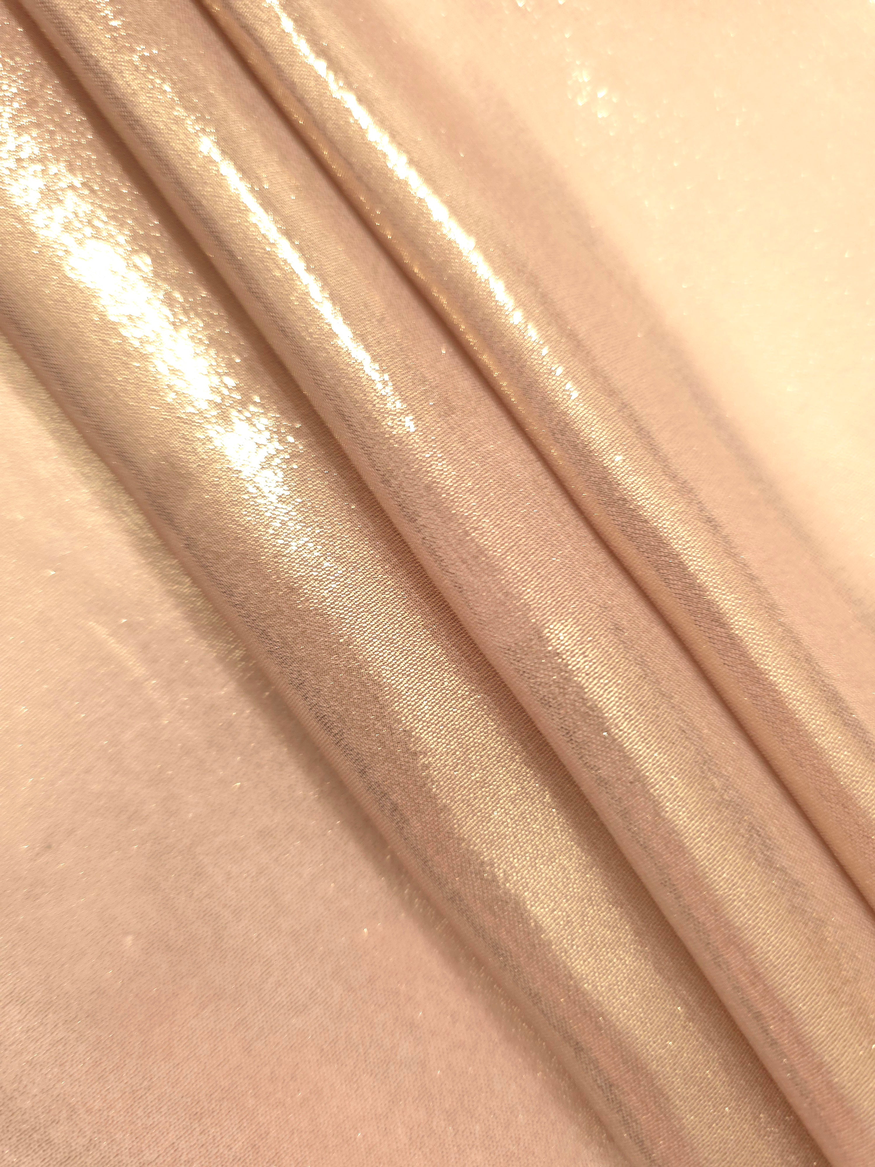 Cream gold flowing folds view of liquid metallic shimmer chiffon fabric, highlighting fluid folds and reflective surface