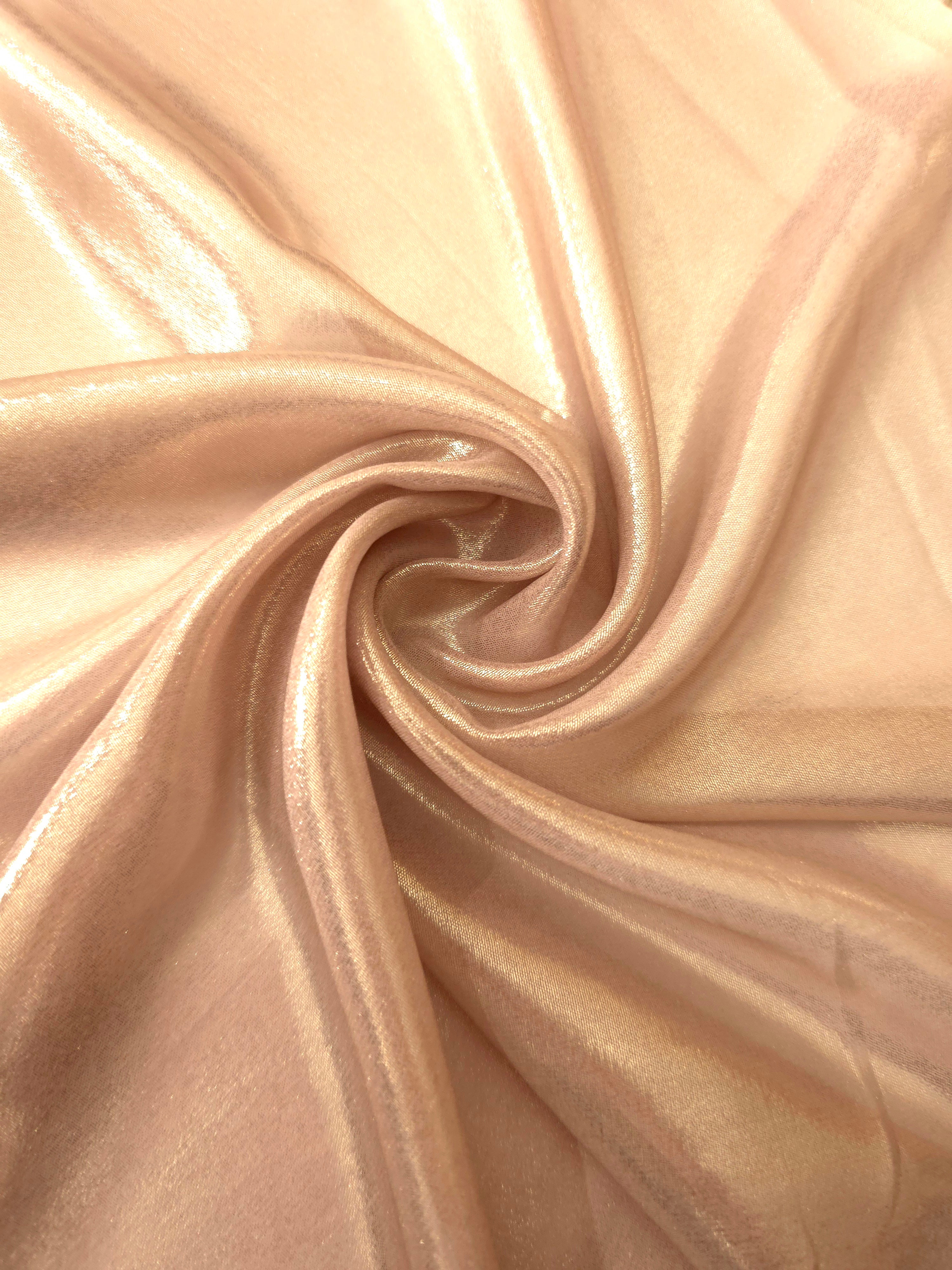 Cream gold shimmer close up view of liquid metallic shimmer chiffon fabric, highlighting fluid folds and reflective surface
