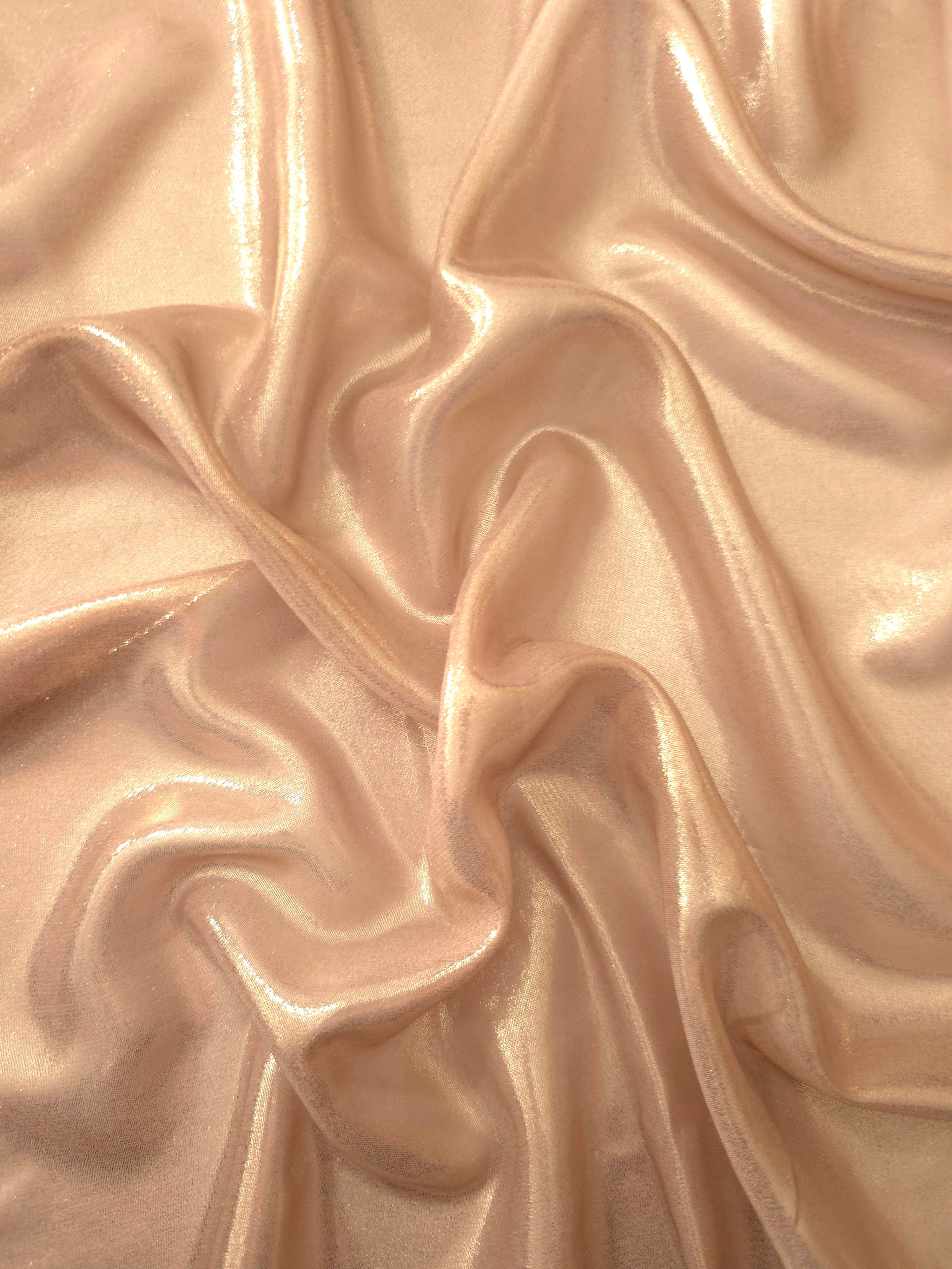 Cream gold surface detail view of liquid metallic shimmer chiffon fabric, highlighting fluid folds and reflective surface