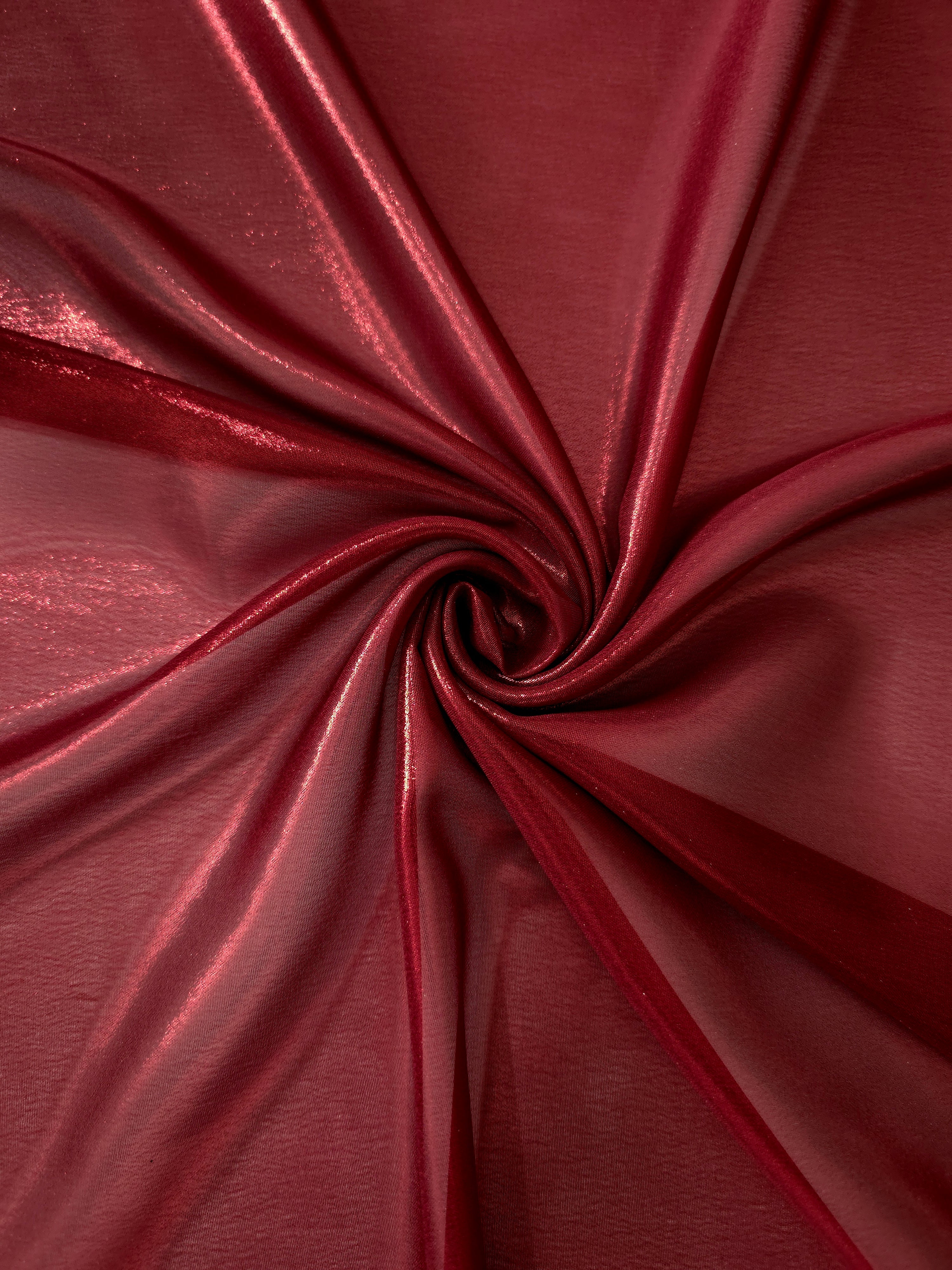 Deep burgundy shimmer close up view of liquid metallic shimmer chiffon fabric, highlighting fluid folds and reflective surface