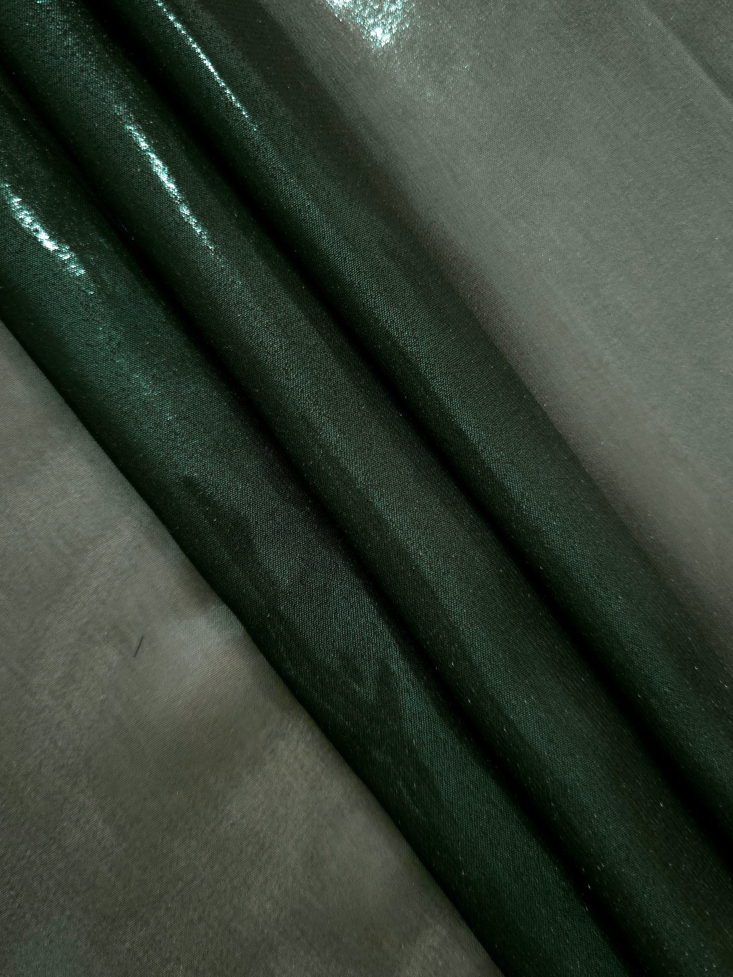 Deep forest flowing folds view of liquid metallic shimmer chiffon fabric, highlighting fluid folds and reflective surface