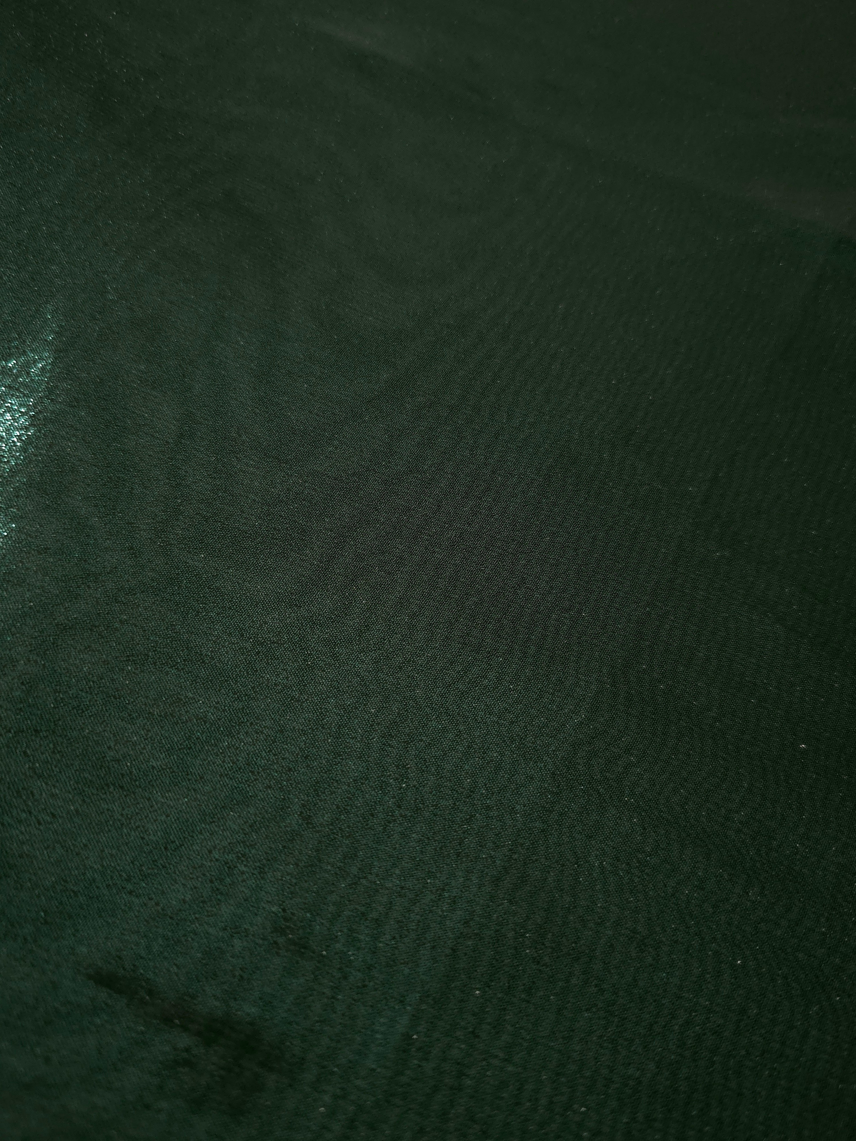 Deep forest fold detail view of liquid metallic shimmer chiffon fabric, highlighting fluid folds and reflective surface