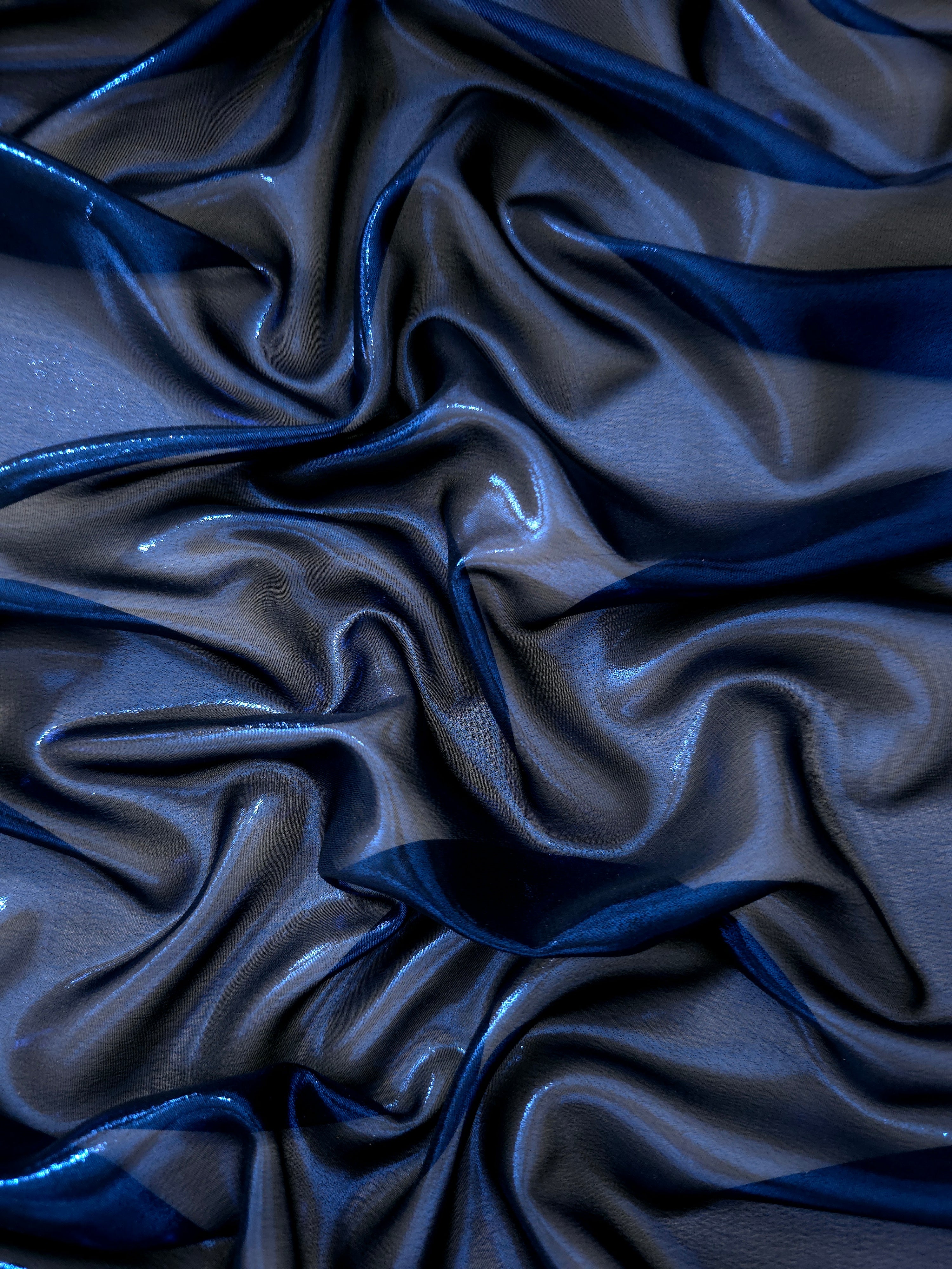 Deep indigo fabric overview of liquid metallic shimmer chiffon fabric, showing lightweight reflective fabric texture and drape