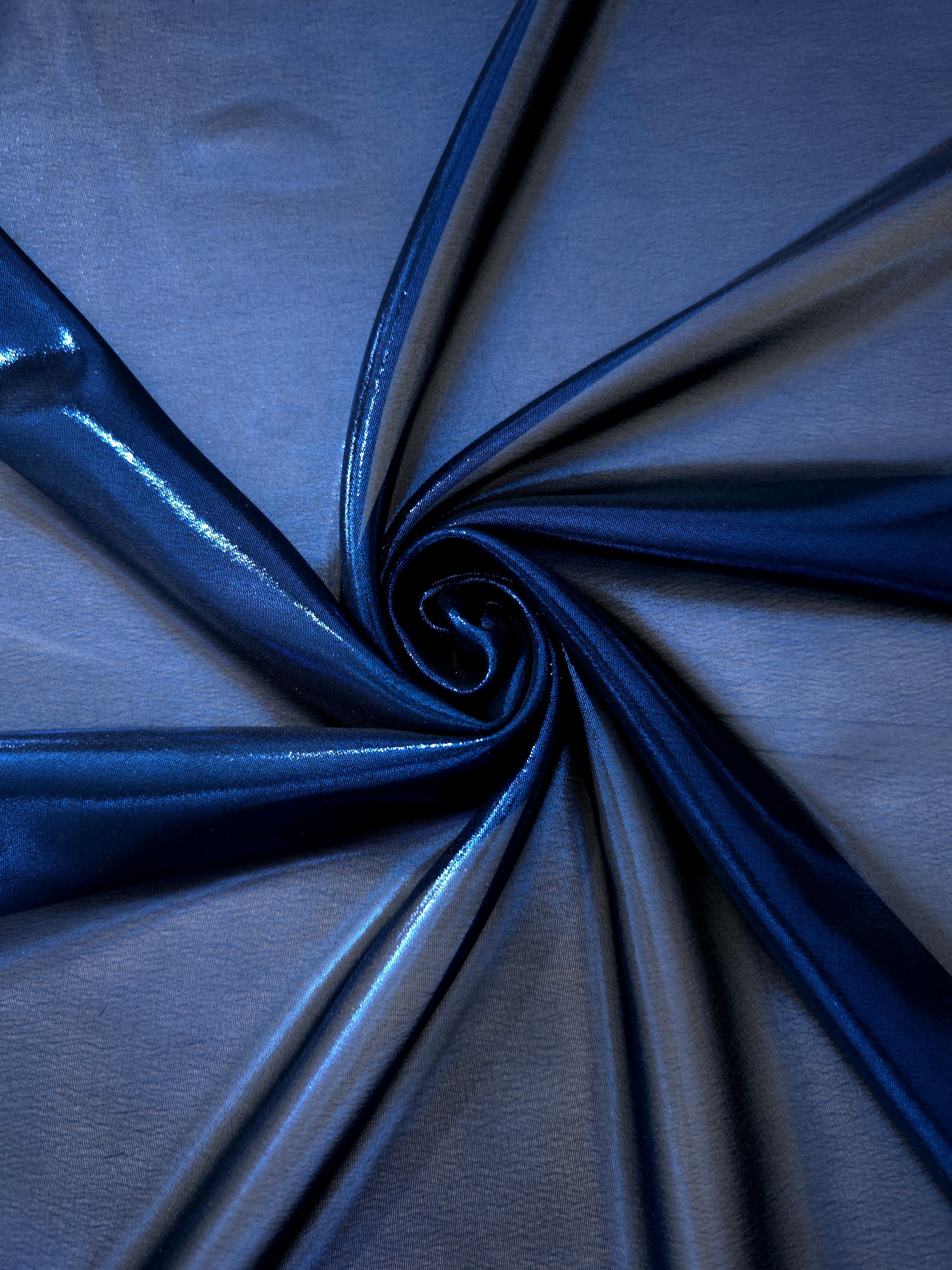 Deep indigo fold detail of liquid metallic shimmer chiffon fabric, showing lightweight reflective fabric texture and drape