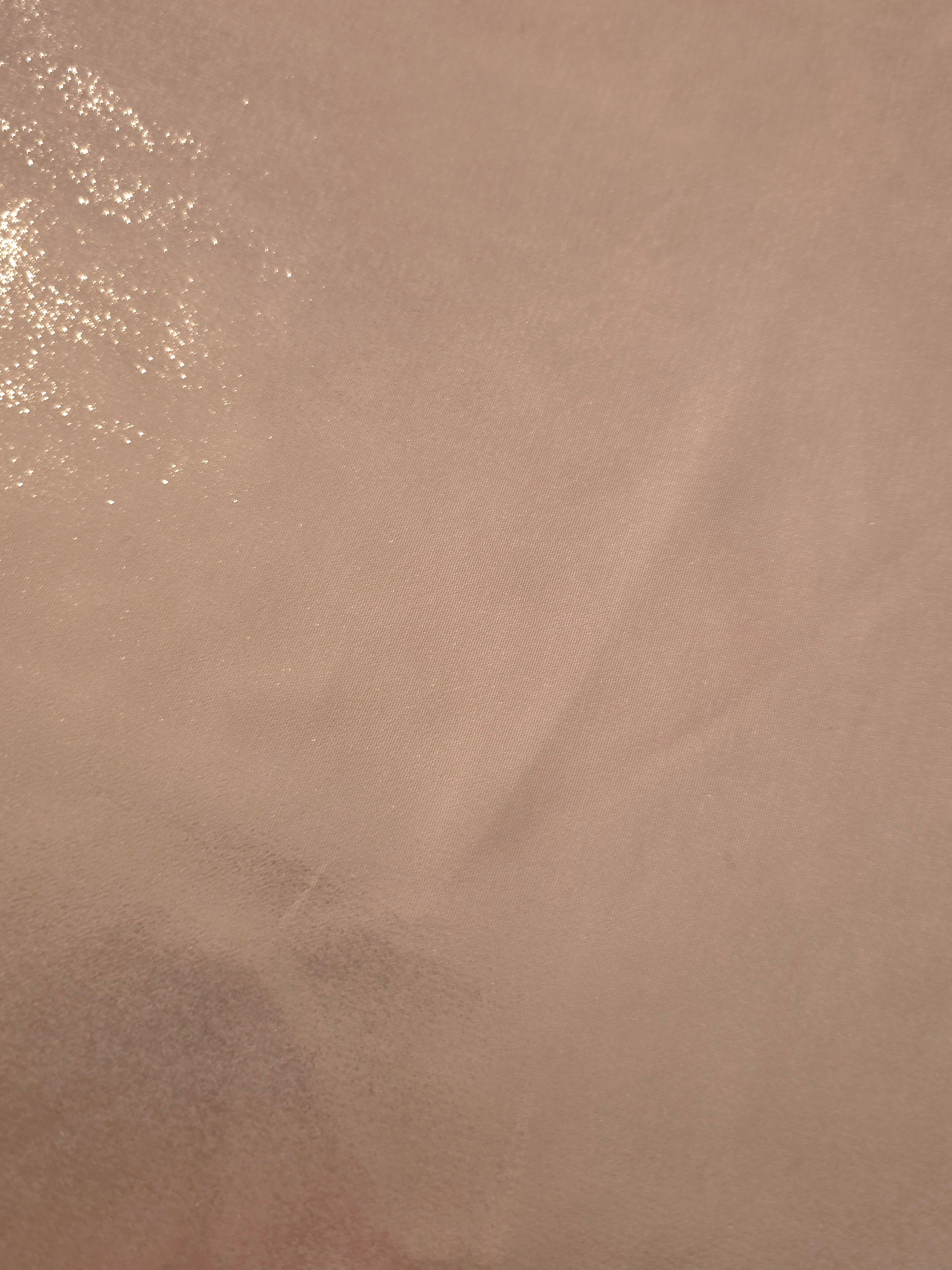 Dusty rose fold detail of liquid metallic shimmer chiffon fabric, showing lightweight reflective fabric texture and drape