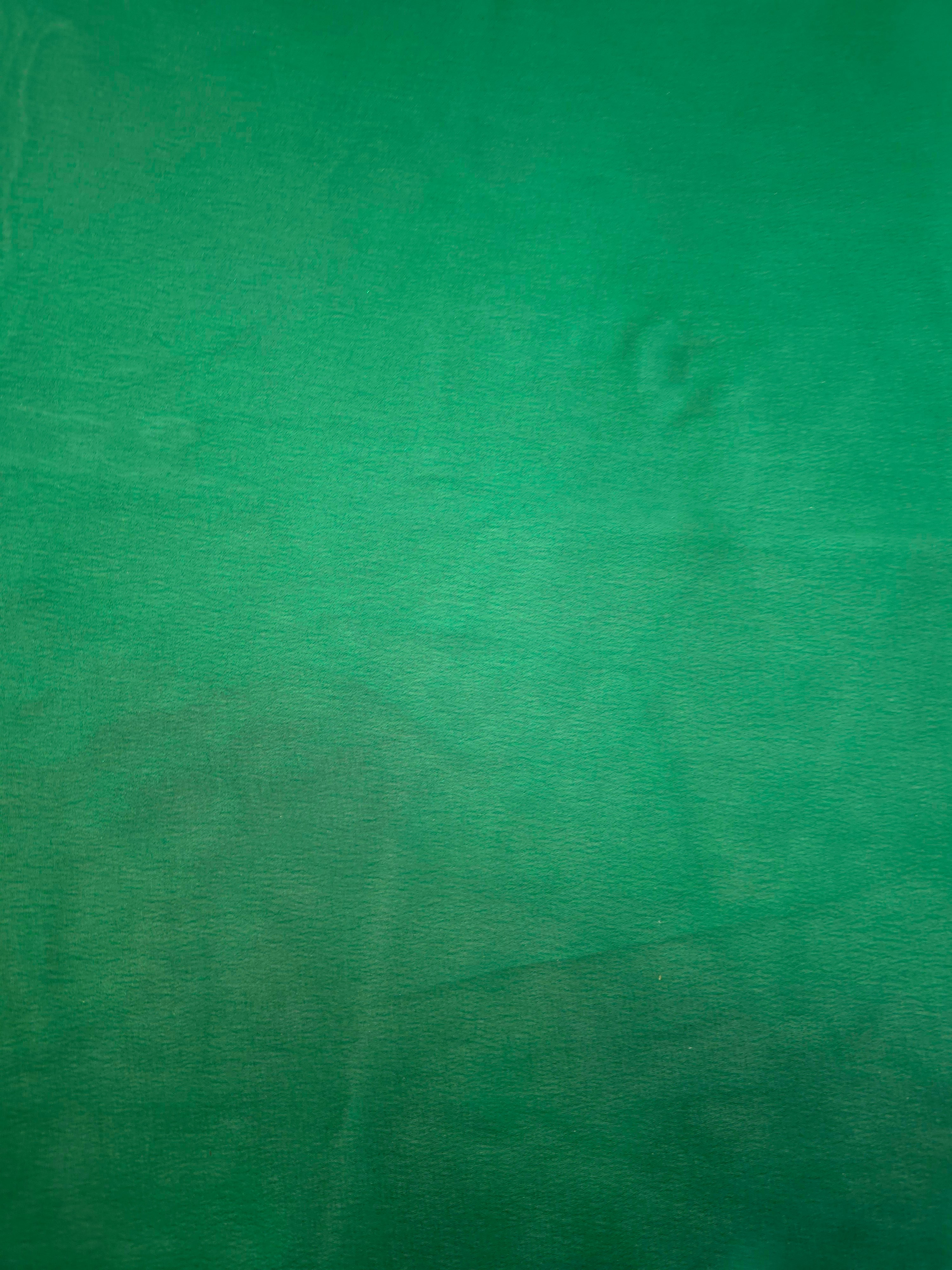 Emerald green fabric overview view of liquid metallic shimmer chiffon fabric, highlighting fluid folds and reflective surface