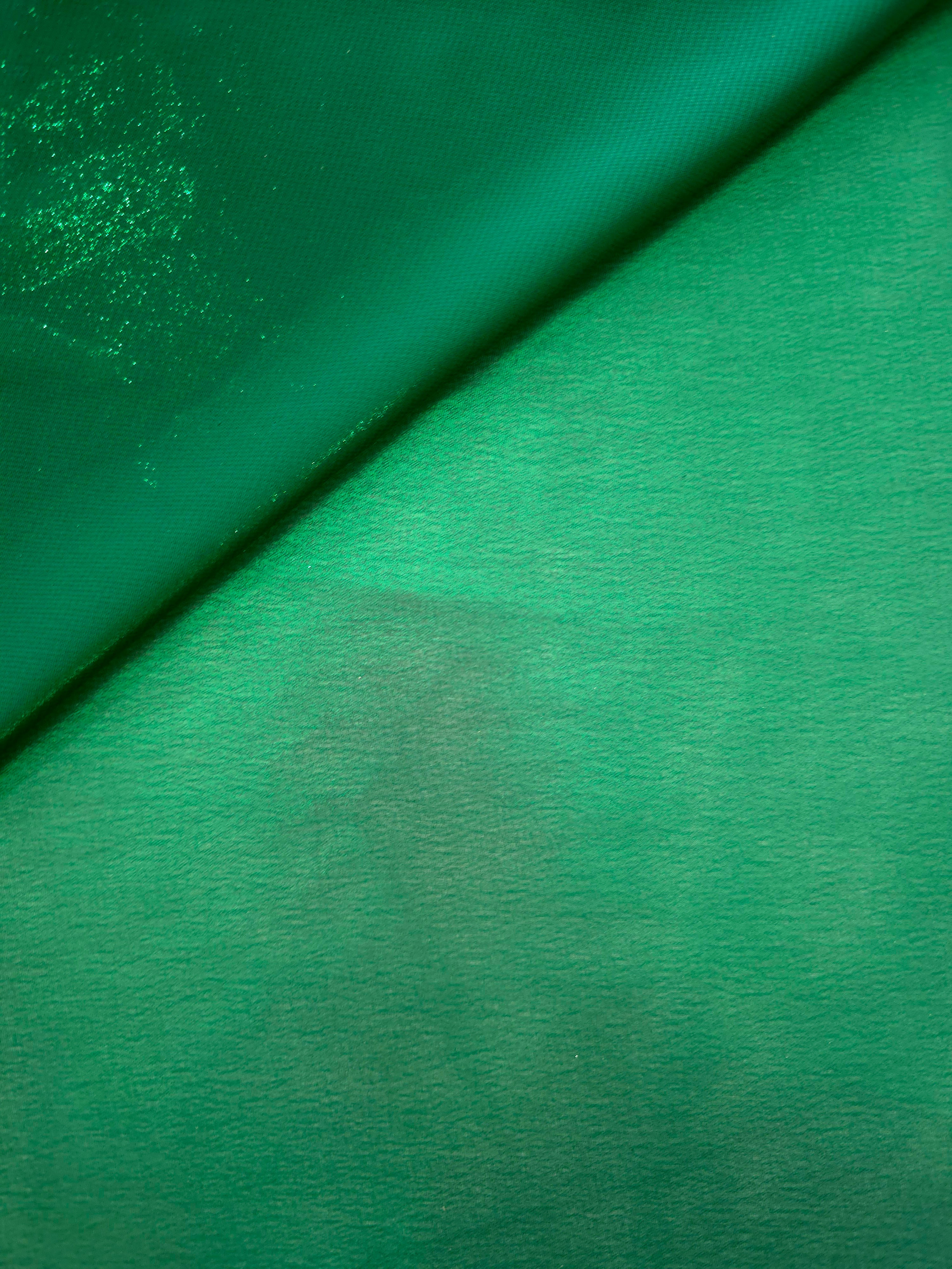 Emerald green soft draping view of liquid metallic shimmer chiffon fabric, highlighting fluid folds and reflective surface