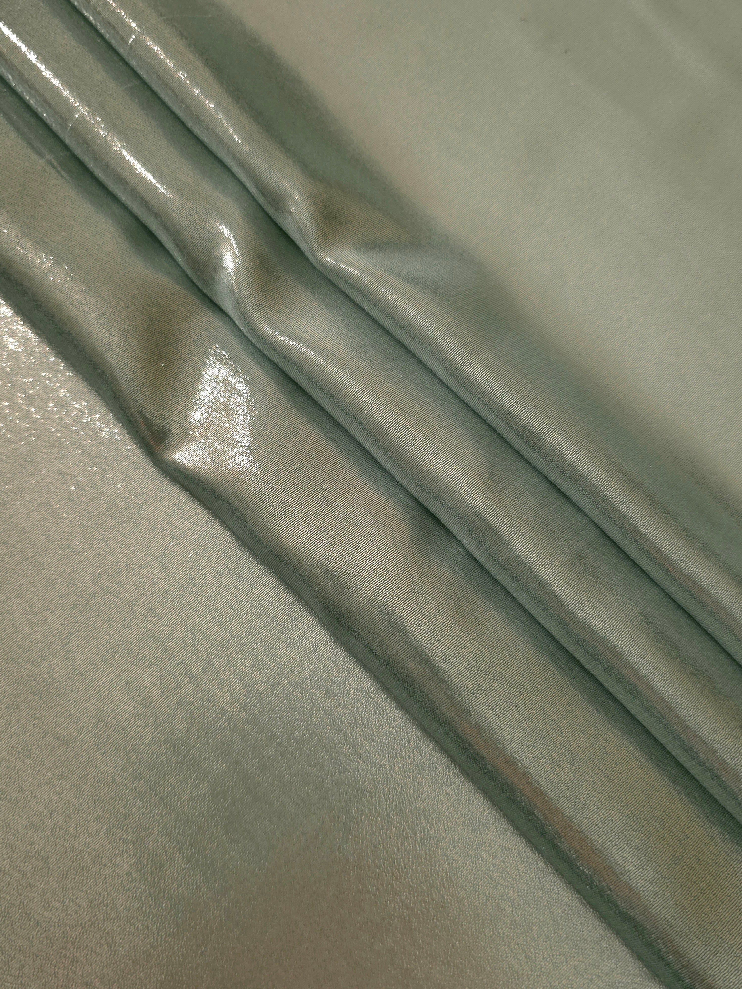 Forest green flowing folds view of liquid metallic shimmer chiffon fabric, highlighting fluid folds and reflective surface