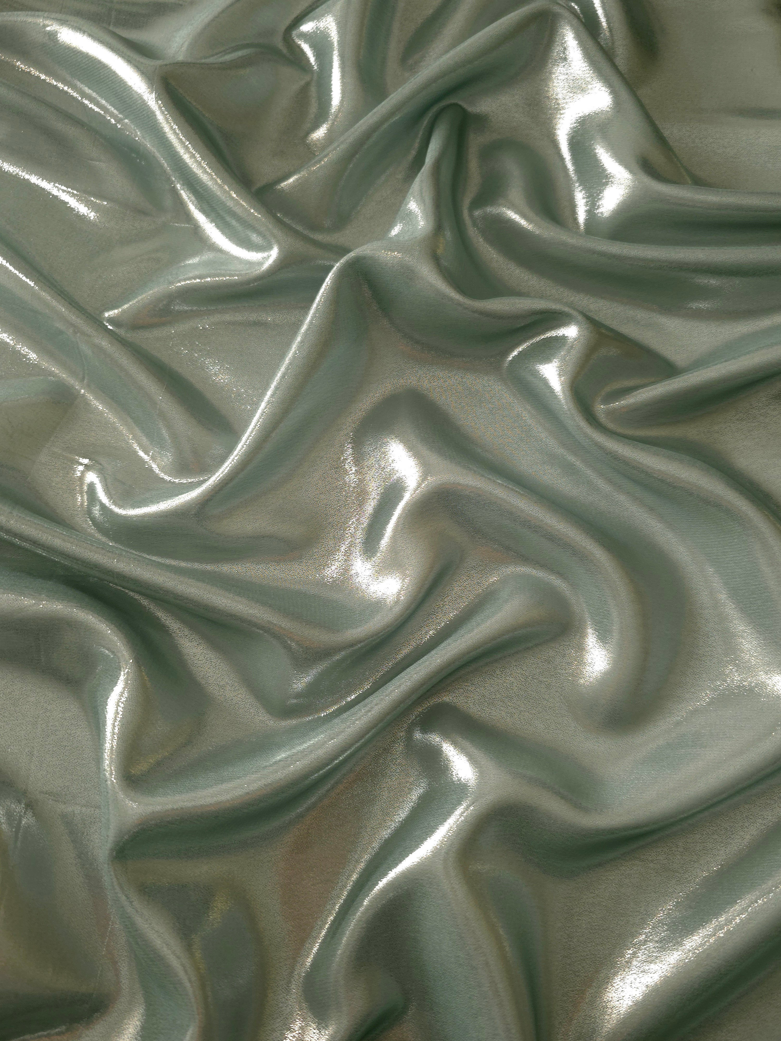 Forest green surface detail view of liquid metallic shimmer chiffon fabric, highlighting fluid folds and reflective surface