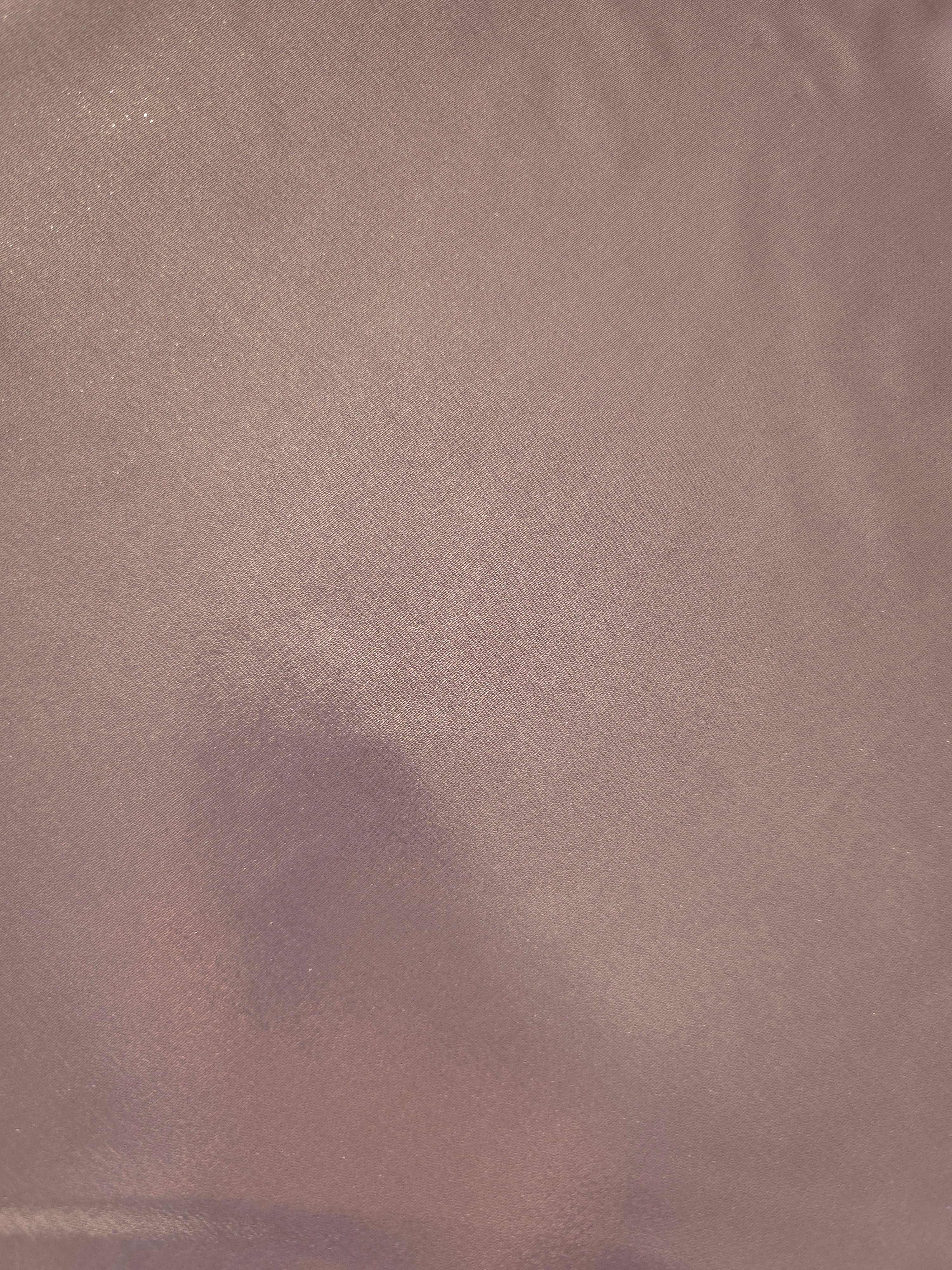 Mauve taupe fold detail of liquid metallic shimmer chiffon fabric, showing lightweight reflective fabric texture and drape