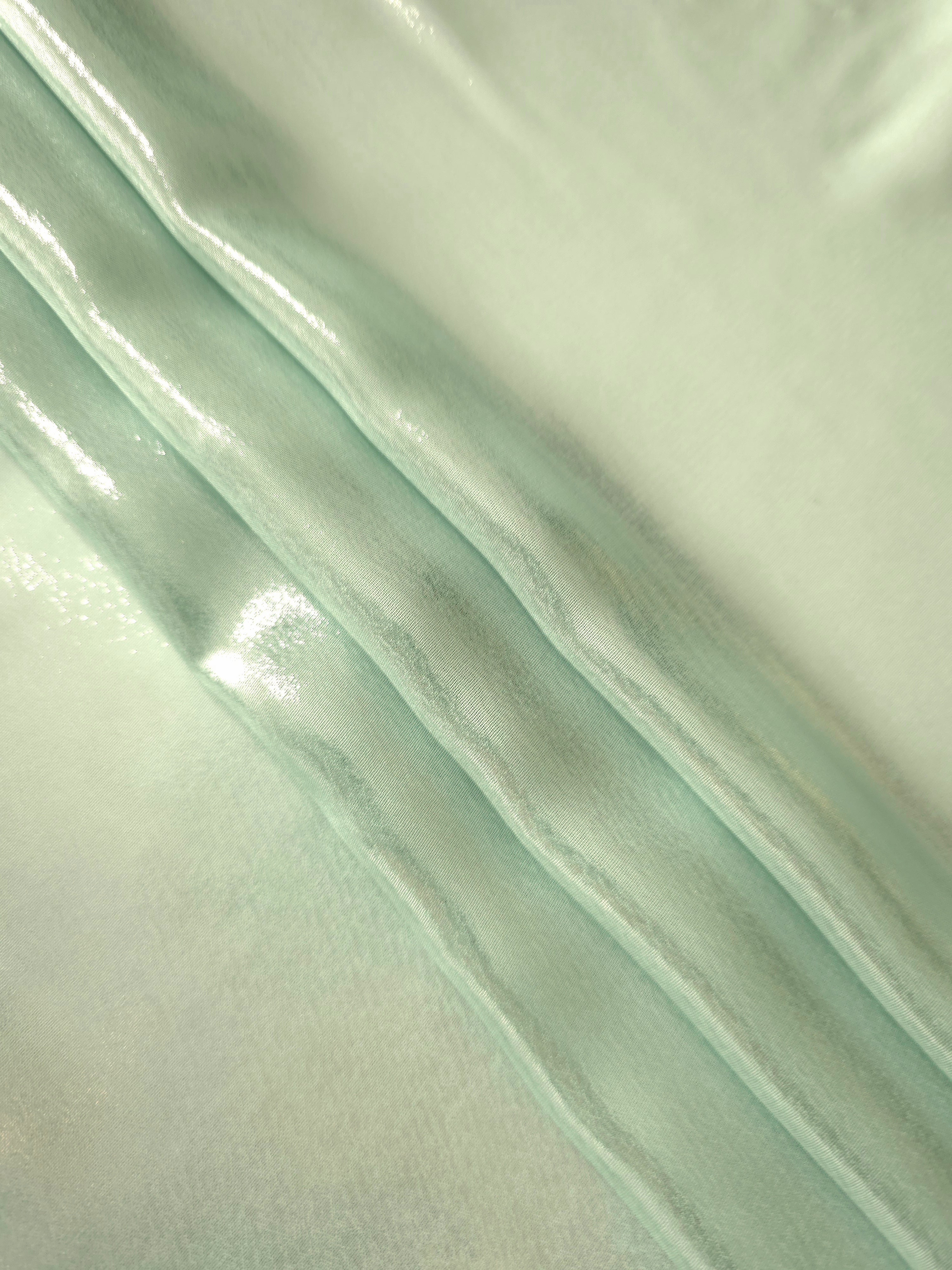 Mint frost flowing folds of liquid metallic shimmer chiffon fabric, showing lightweight reflective fabric texture and drape