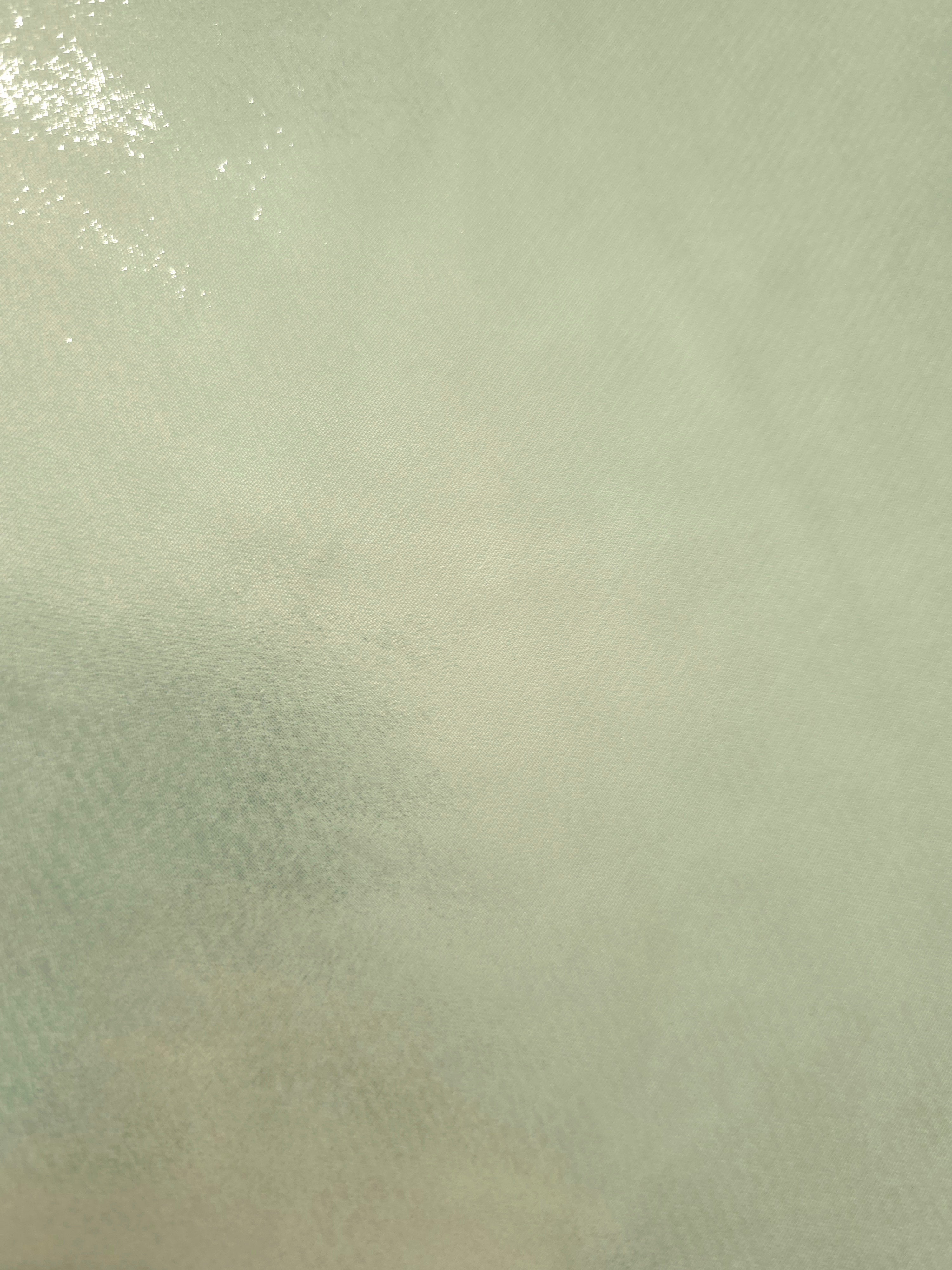 Mint frost fold detail of liquid metallic shimmer chiffon fabric, showing lightweight reflective fabric texture and drape