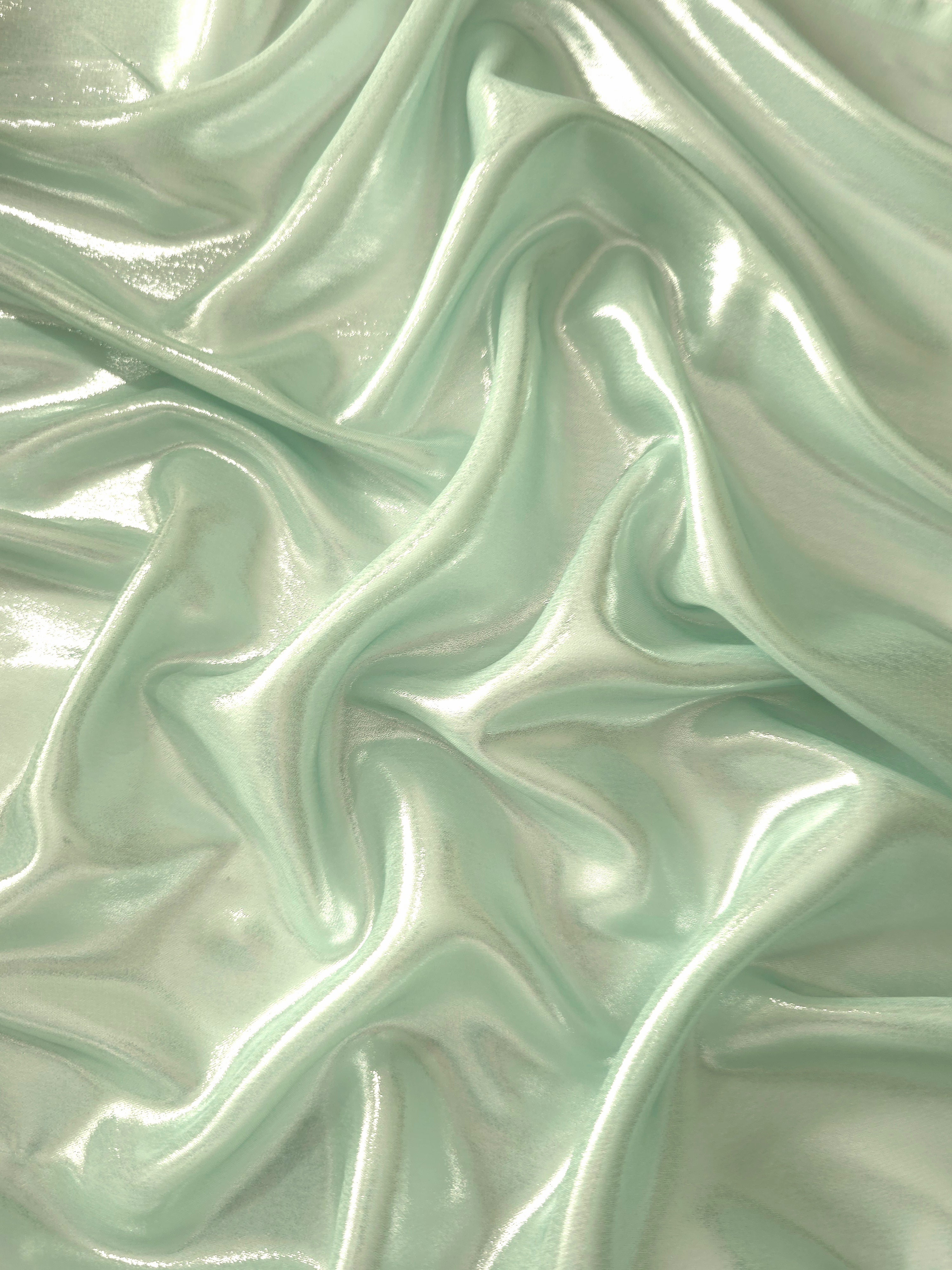 Mint frost surface detail of liquid metallic shimmer chiffon fabric, showing lightweight reflective fabric texture and drape