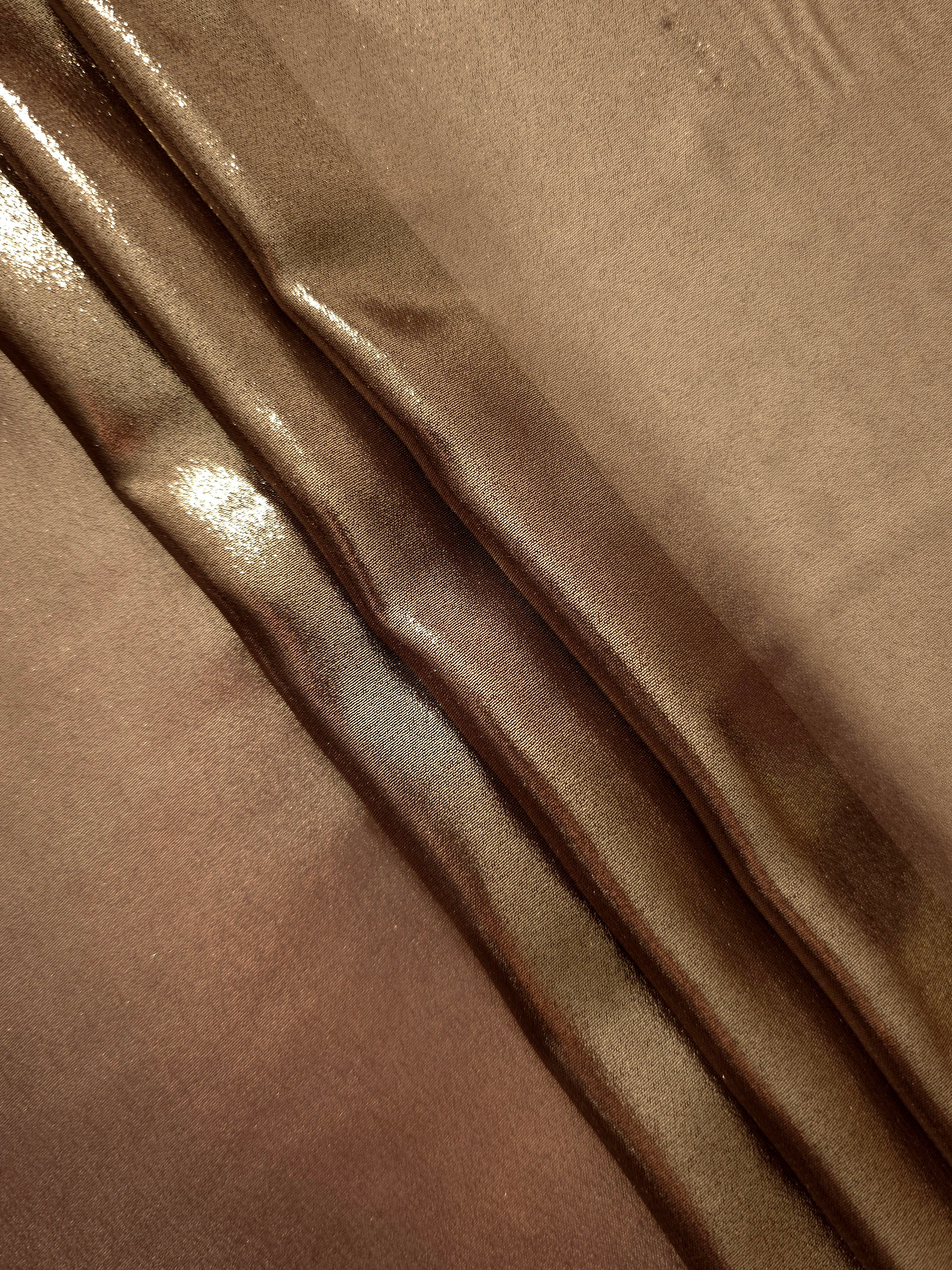 Mocha brown flowing folds view of liquid metallic shimmer chiffon fabric, highlighting fluid folds and reflective surface