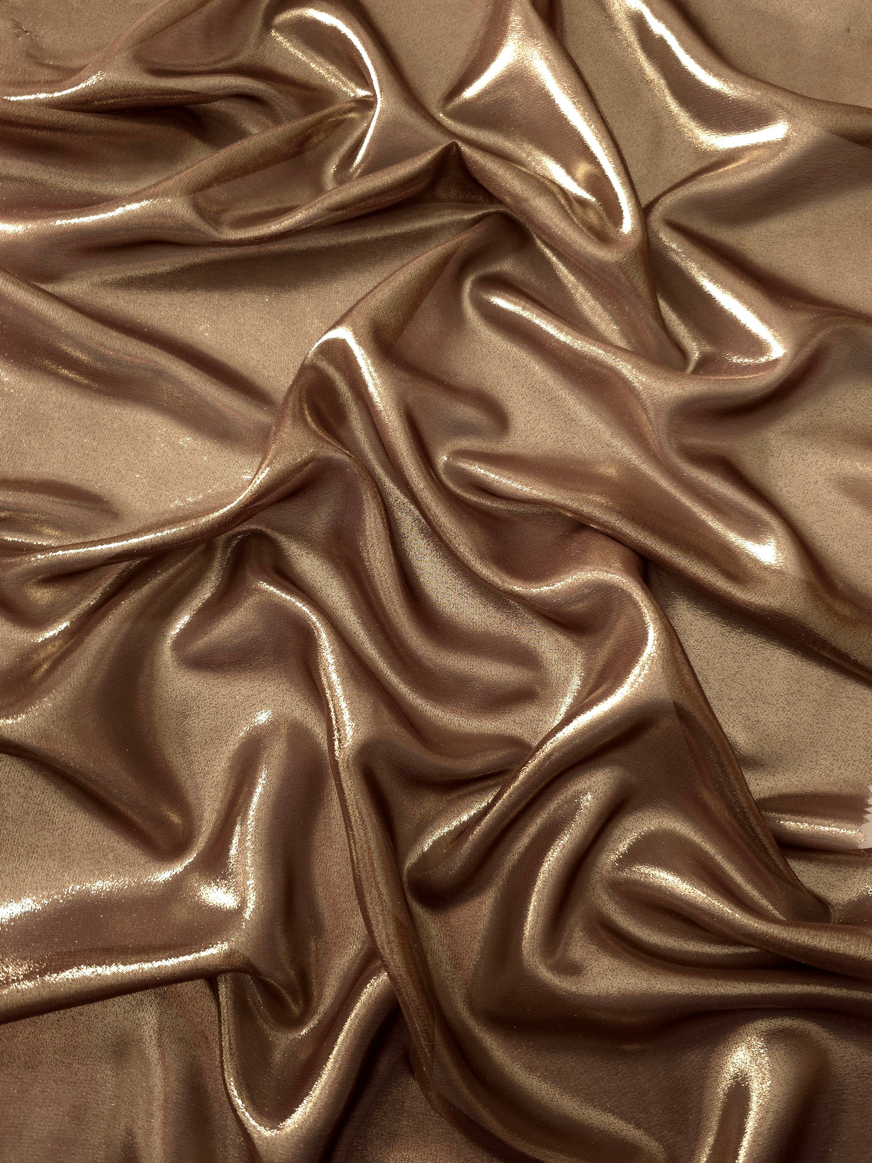 Mocha brown surface detail view of liquid metallic shimmer chiffon fabric, highlighting fluid folds and reflective surface