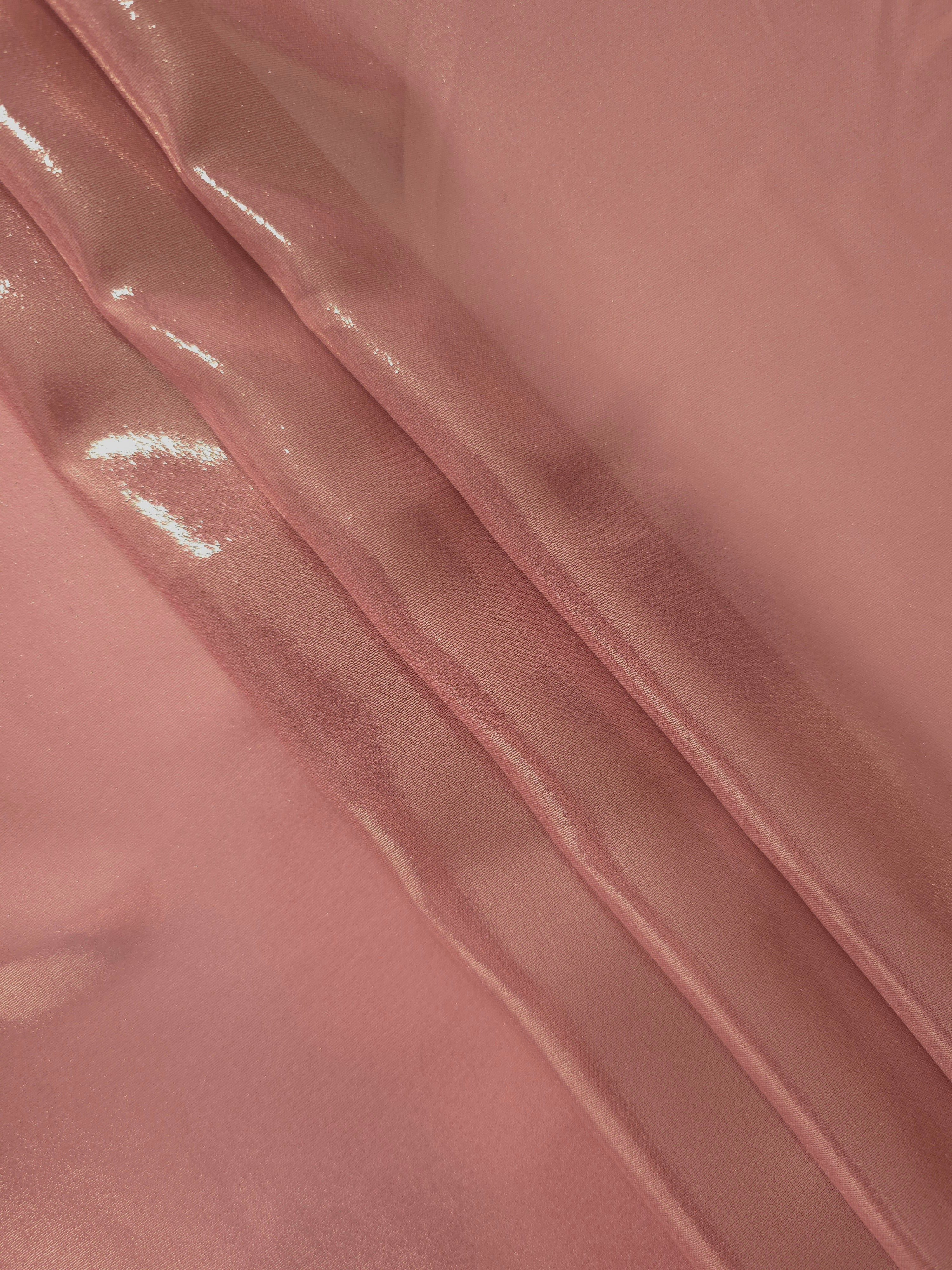 Muted rose flowing folds view of liquid metallic shimmer chiffon fabric, highlighting fluid folds and reflective surface