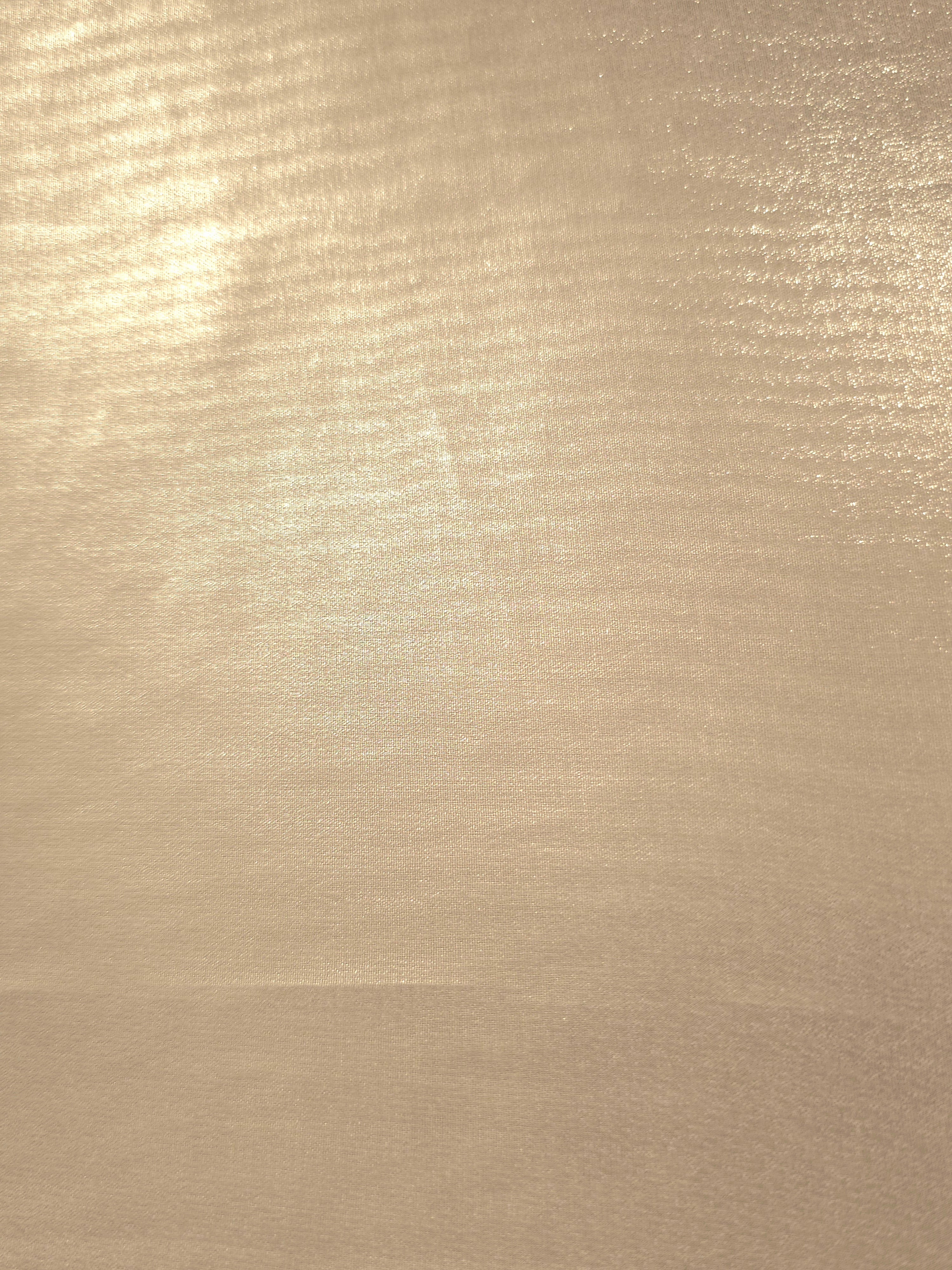 Nude champagne fabric overview of liquid metallic shimmer chiffon fabric, showing lightweight reflective fabric texture and drape