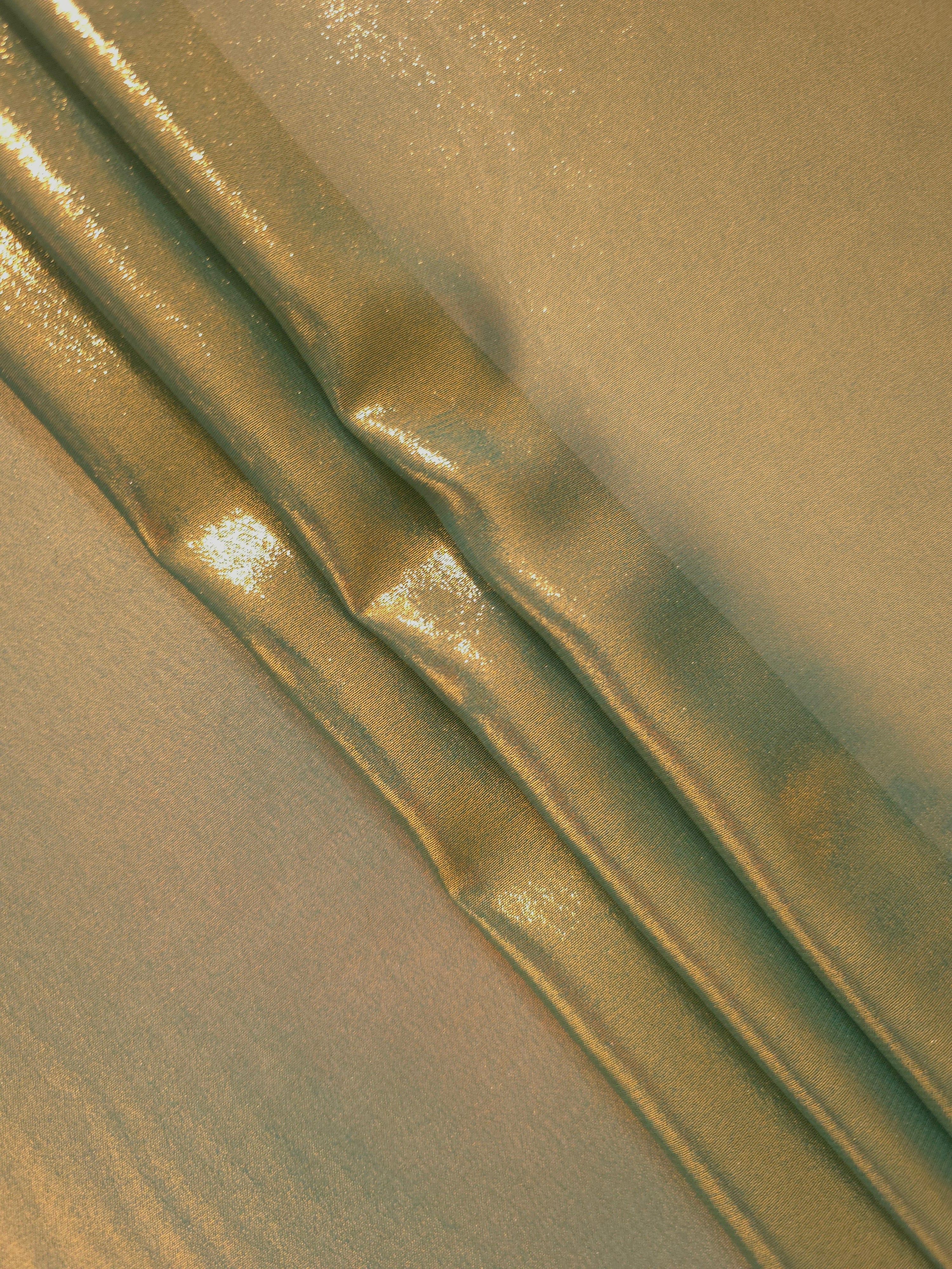 Olive gold flowing folds view of liquid metallic shimmer chiffon fabric, highlighting fluid folds and reflective surface