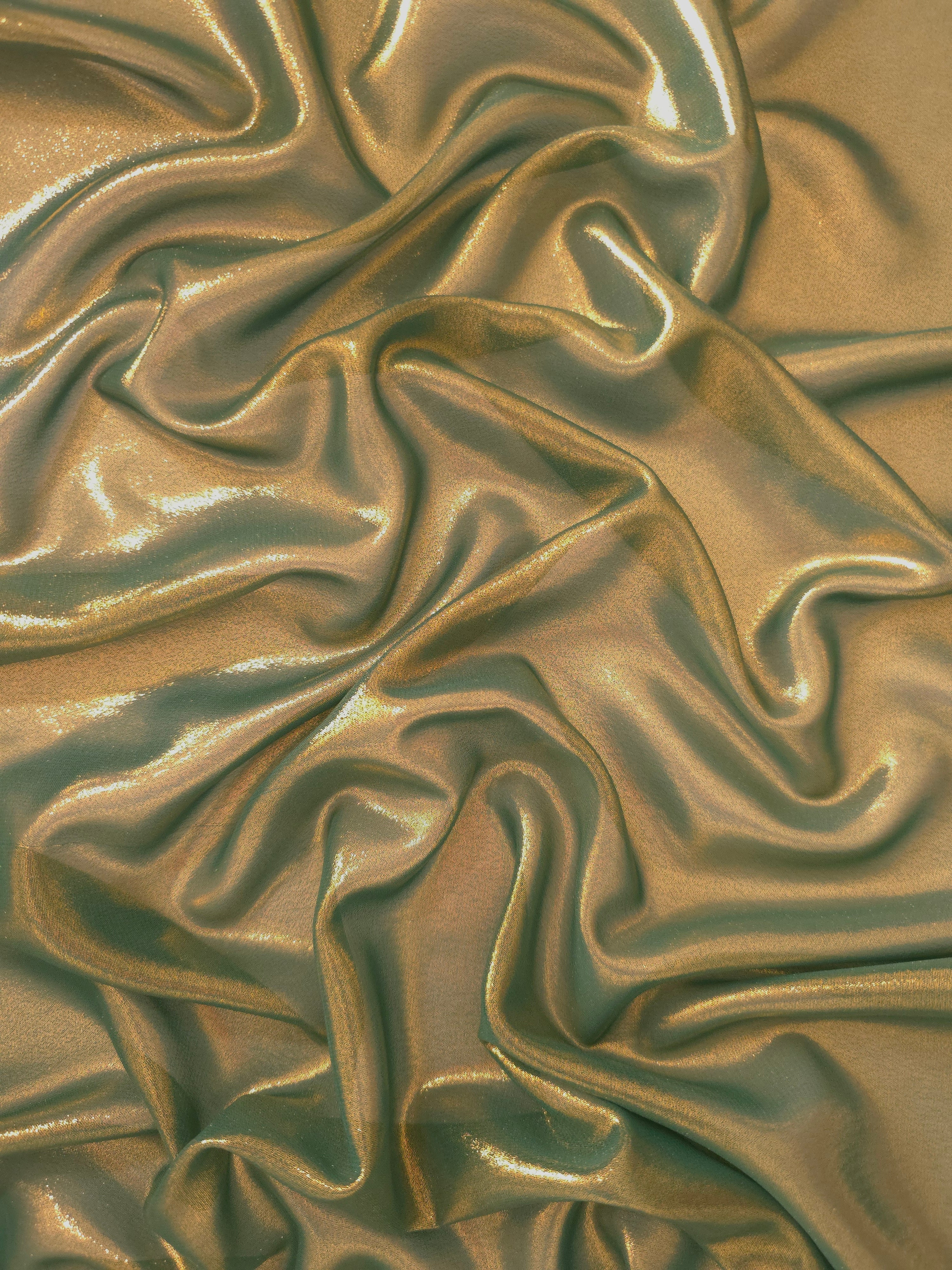 Olive gold surface detail view of liquid metallic shimmer chiffon fabric, highlighting fluid folds and reflective surface