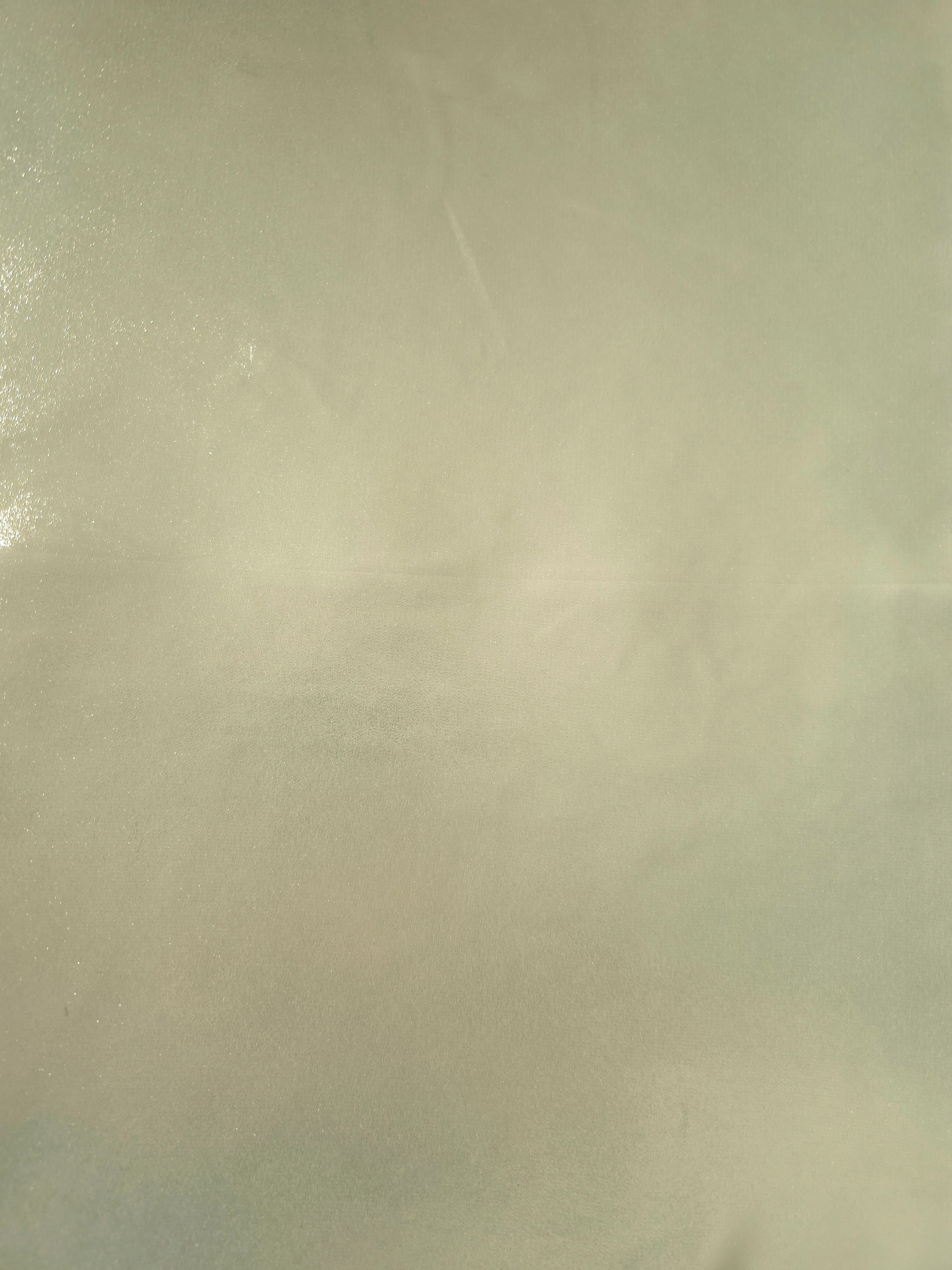 Pale pistachio fabric overview of liquid metallic shimmer chiffon fabric, showing lightweight reflective fabric texture and drape