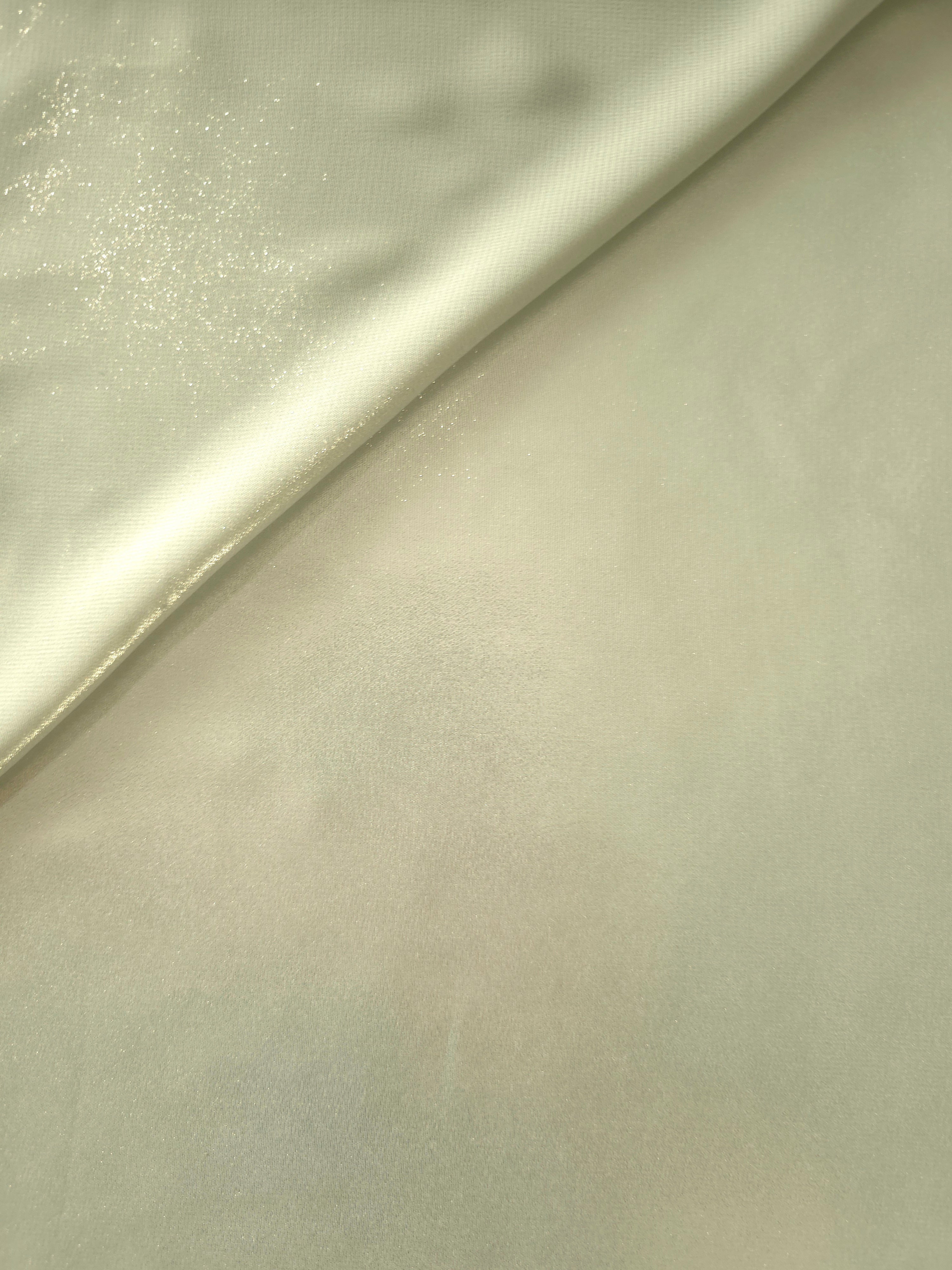 Pale pistachio soft draping of liquid metallic shimmer chiffon fabric, showing lightweight reflective fabric texture and drape