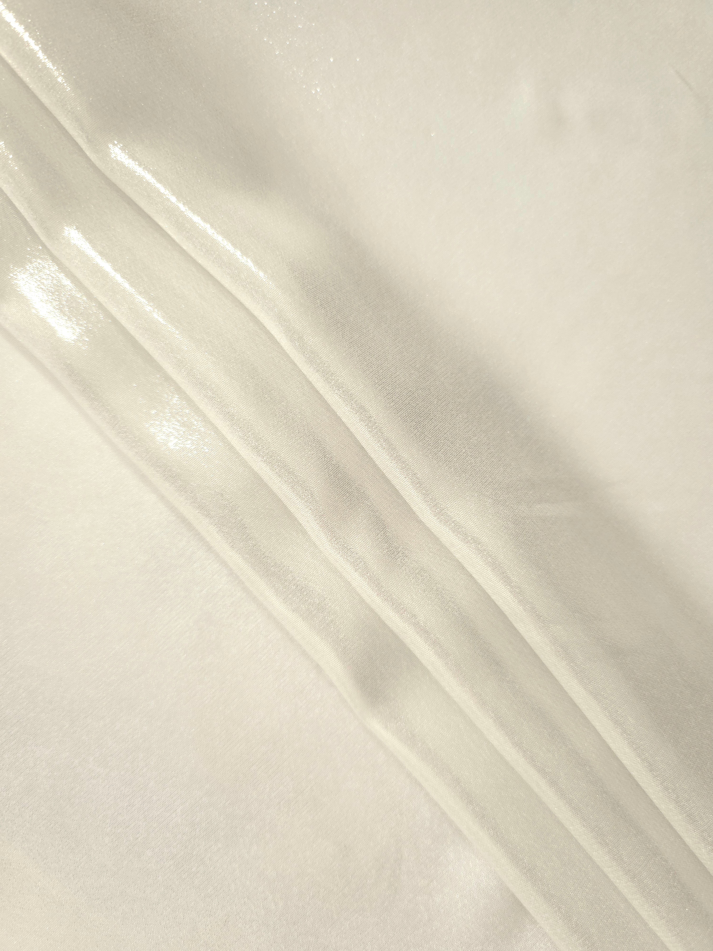 Pearl white flowing folds of liquid metallic shimmer chiffon fabric, showing lightweight reflective fabric texture and drape