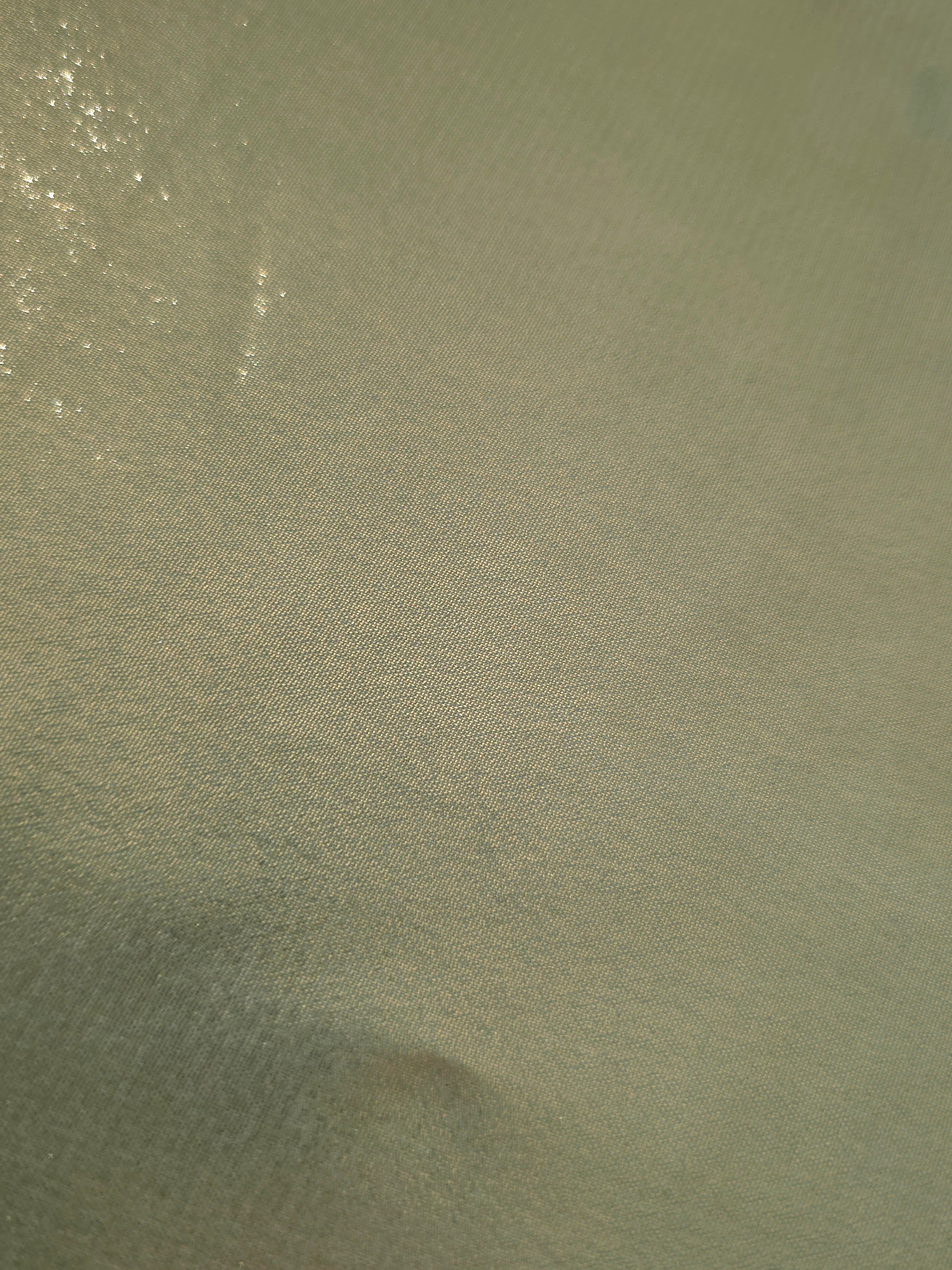 Sage green fold detail view of liquid metallic shimmer chiffon fabric, highlighting fluid folds and reflective surface
