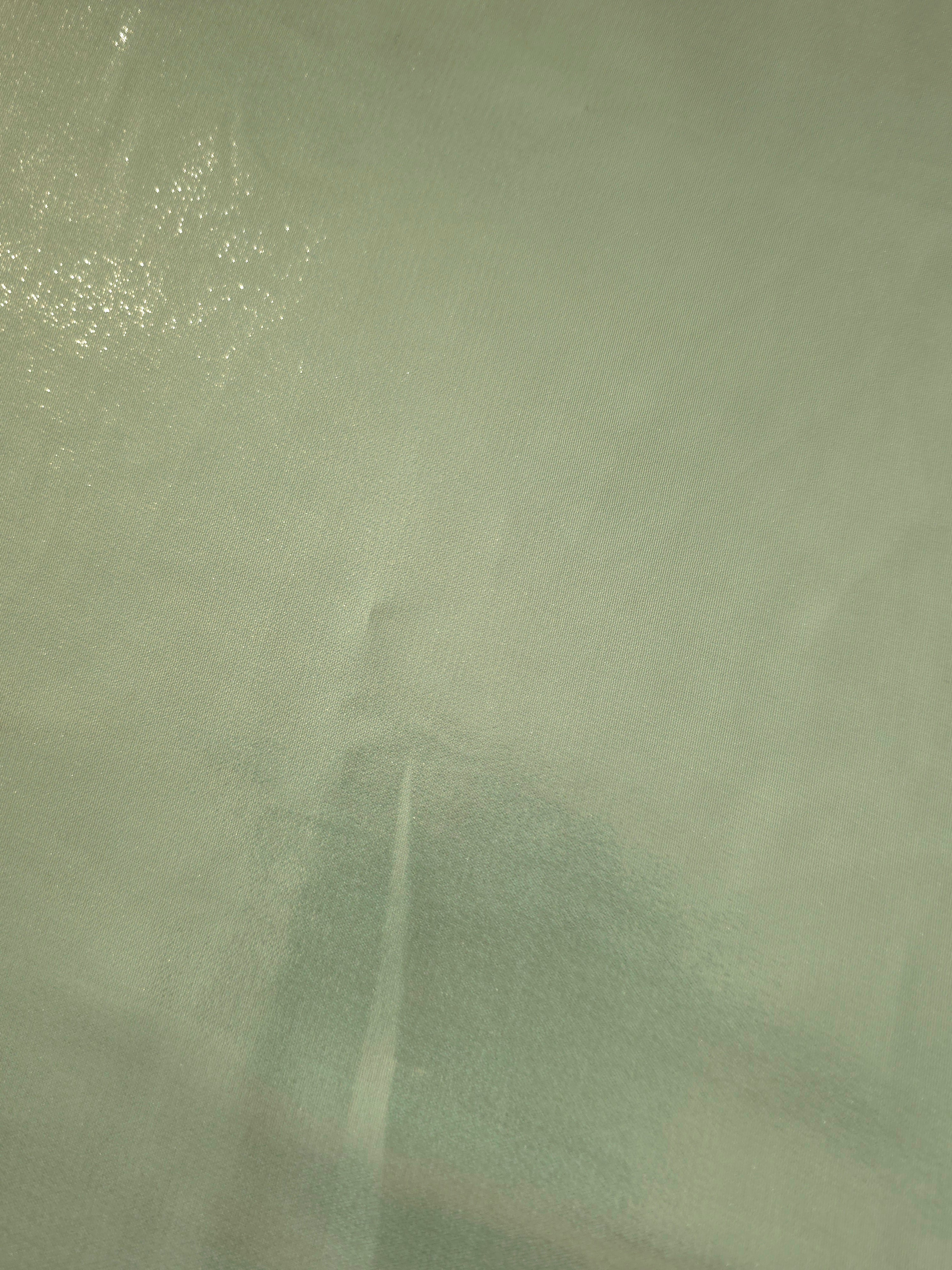 Sage silver fold detail of liquid metallic shimmer chiffon fabric, showing lightweight reflective fabric texture and drape