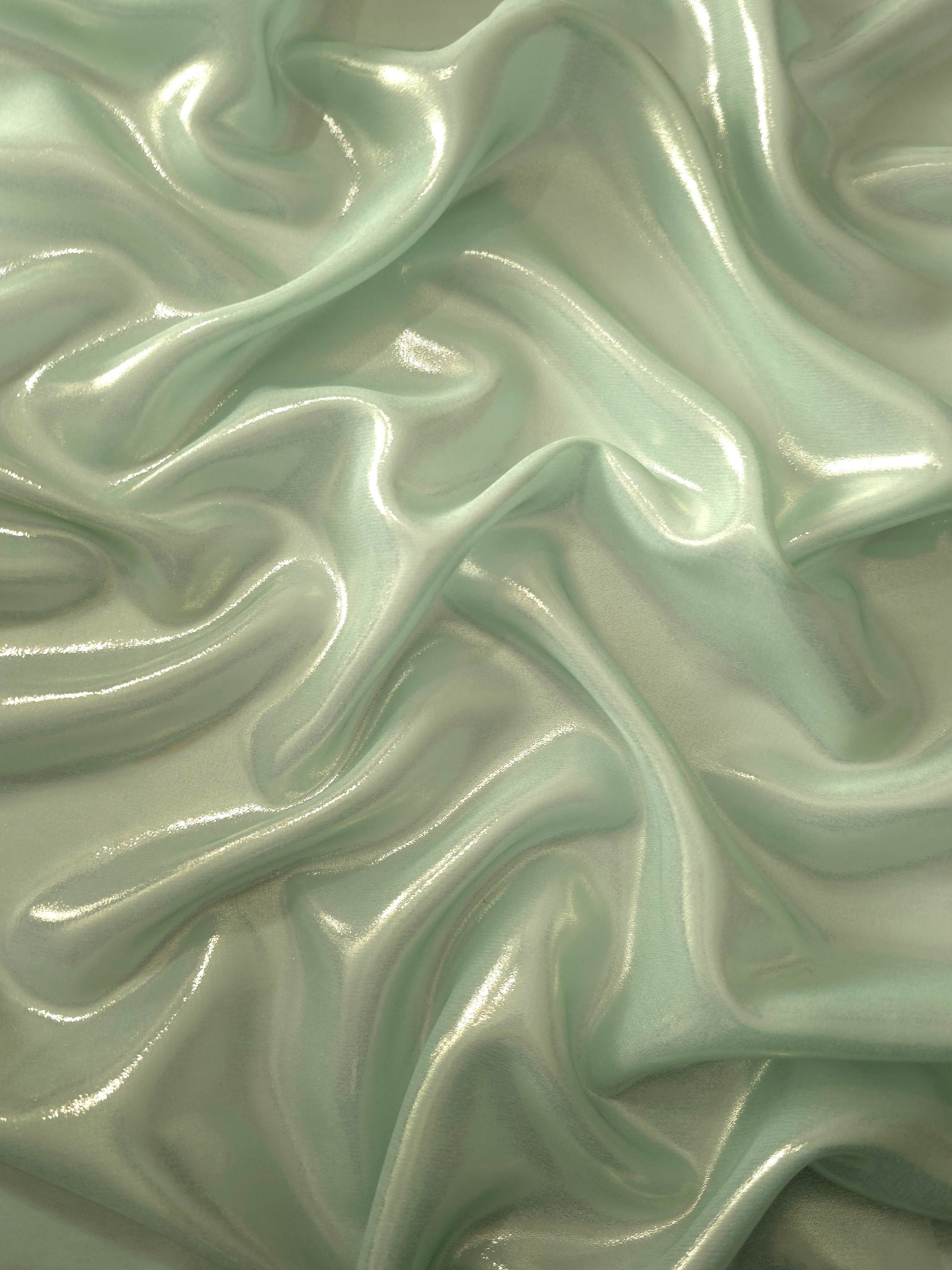 Sage silver surface detail of liquid metallic shimmer chiffon fabric, showing lightweight reflective fabric texture and drape