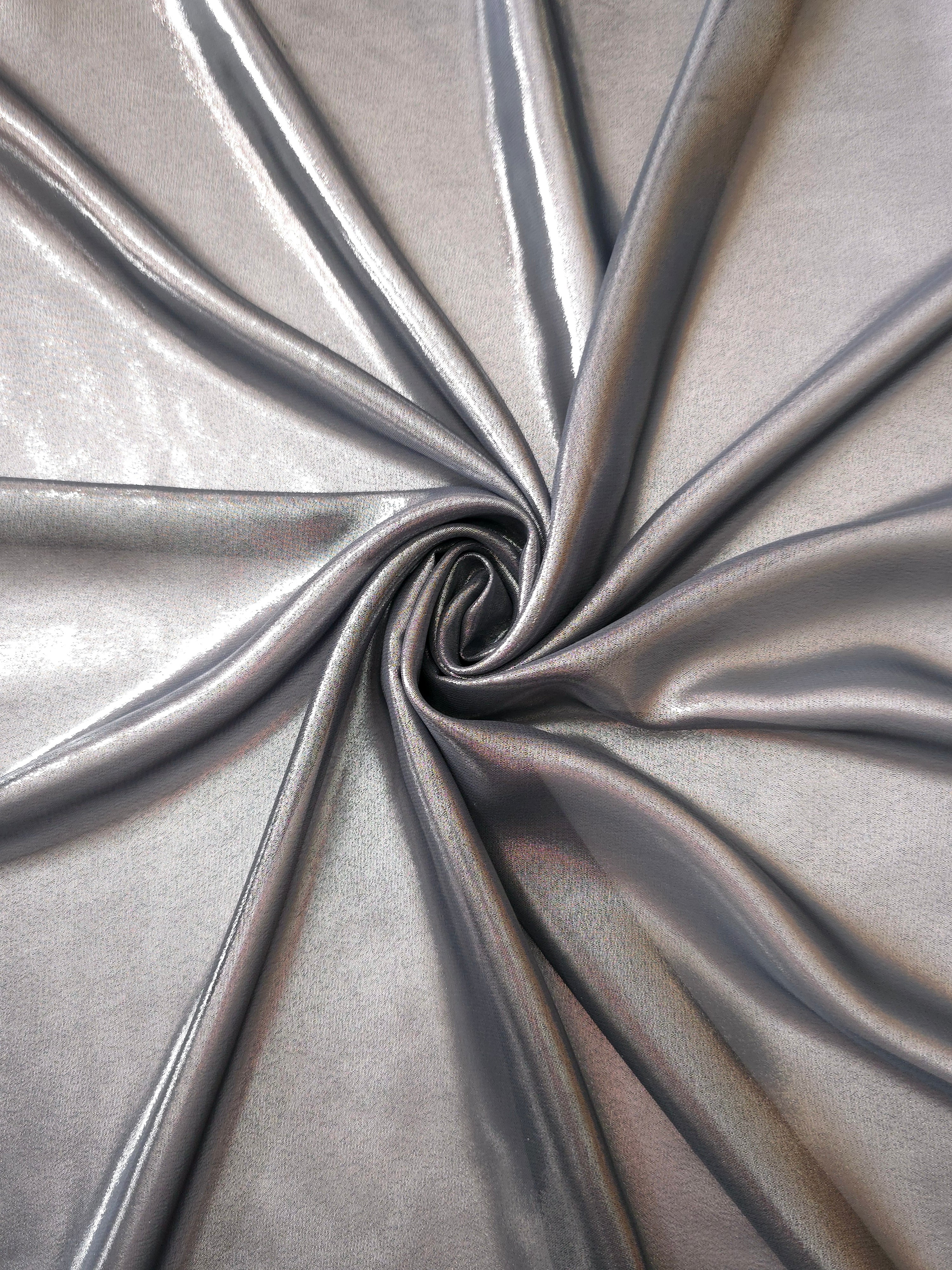 Silver gray shimmer close up view of liquid metallic shimmer chiffon fabric, highlighting fluid folds and reflective surface