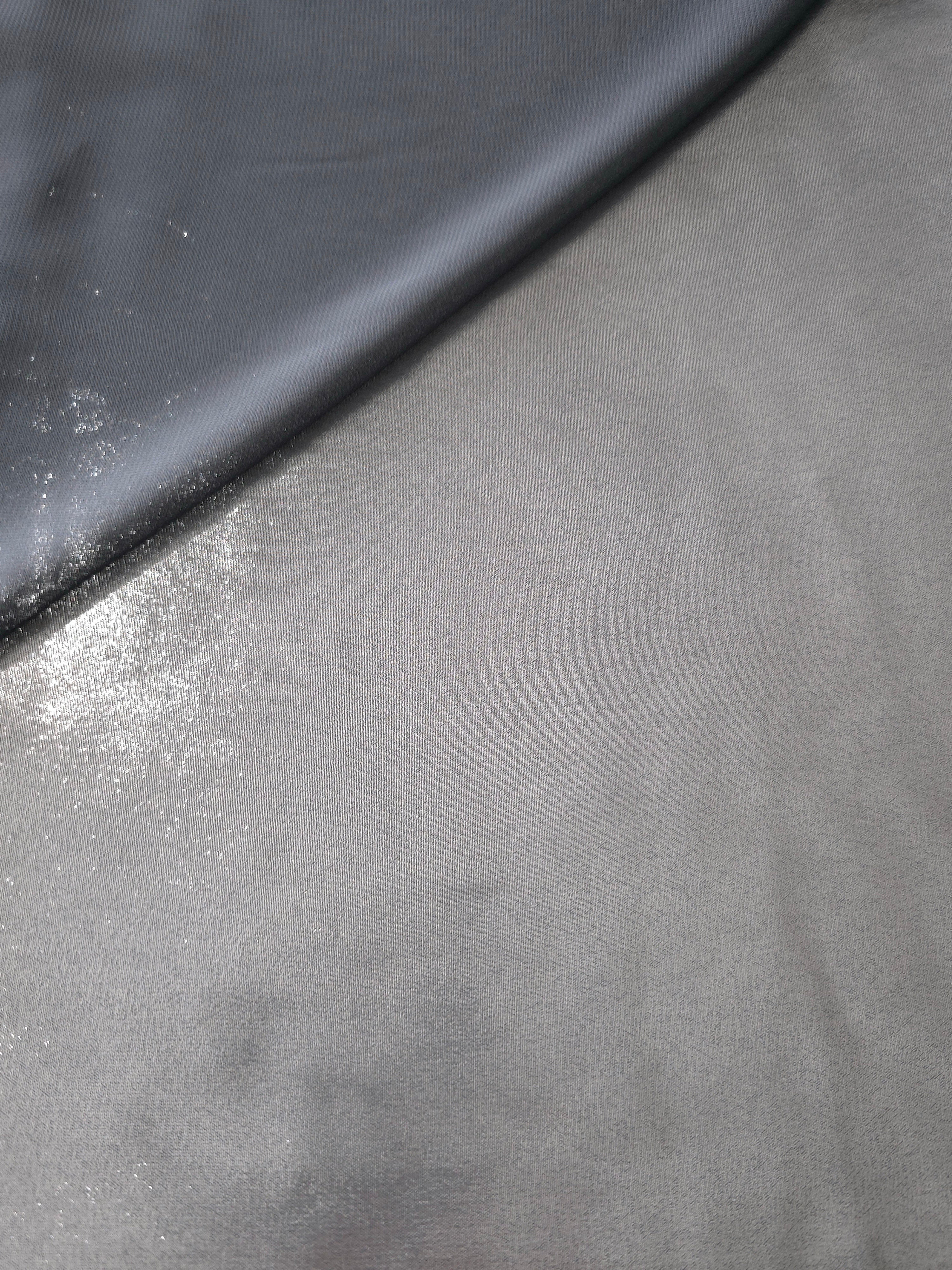 Silver gray soft draping view of liquid metallic shimmer chiffon fabric, highlighting fluid folds and reflective surface
