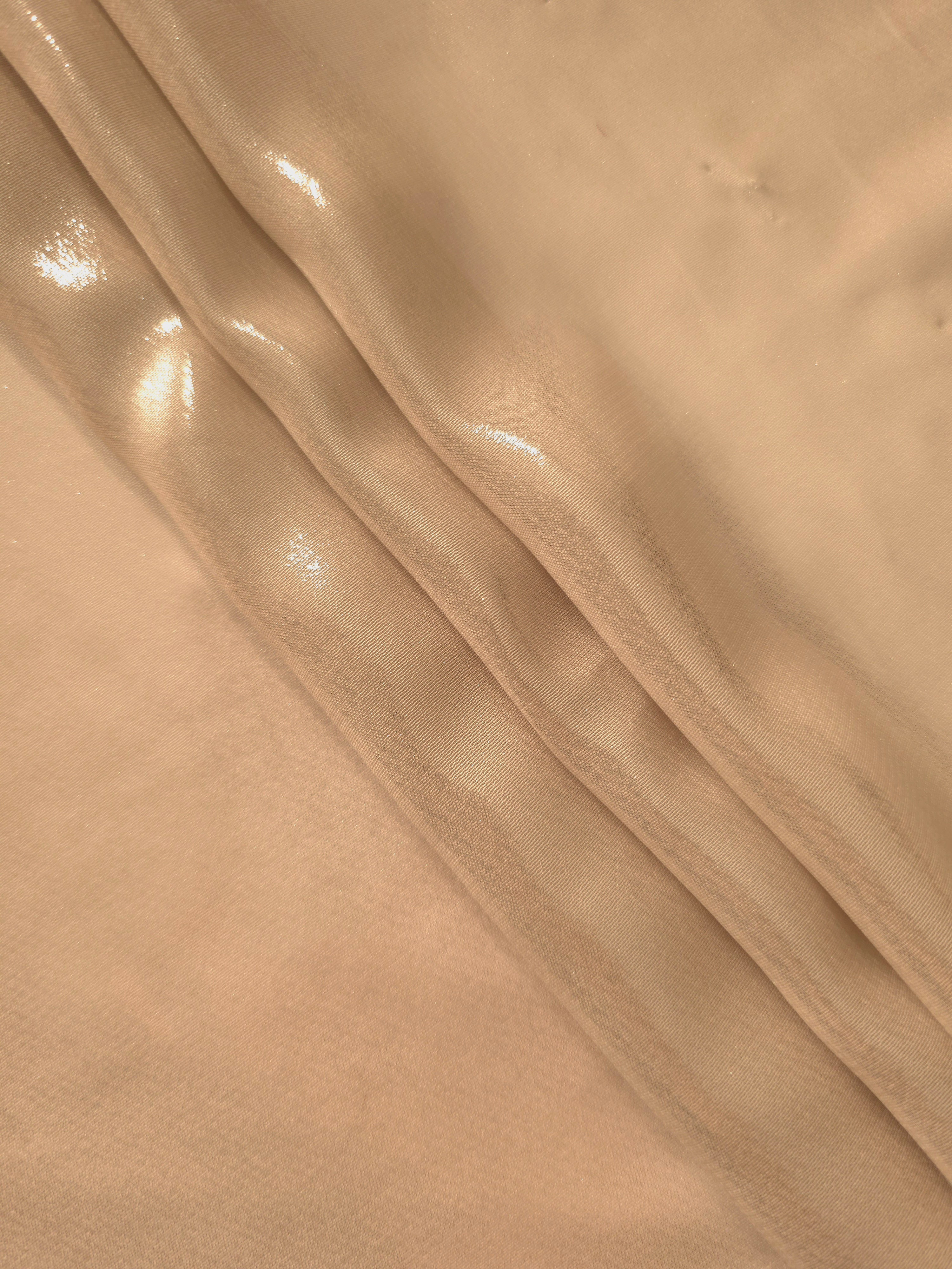 Soft taupe flowing folds of liquid metallic shimmer chiffon fabric, showing lightweight reflective fabric texture and drape