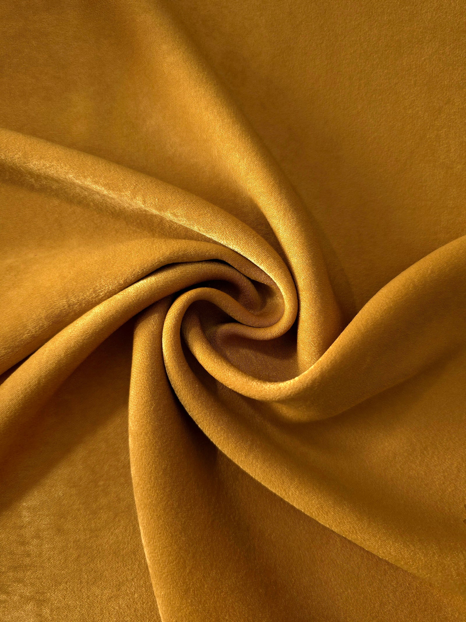 Golden Brown sandwashed polyamide fabric showing a soft folded drape