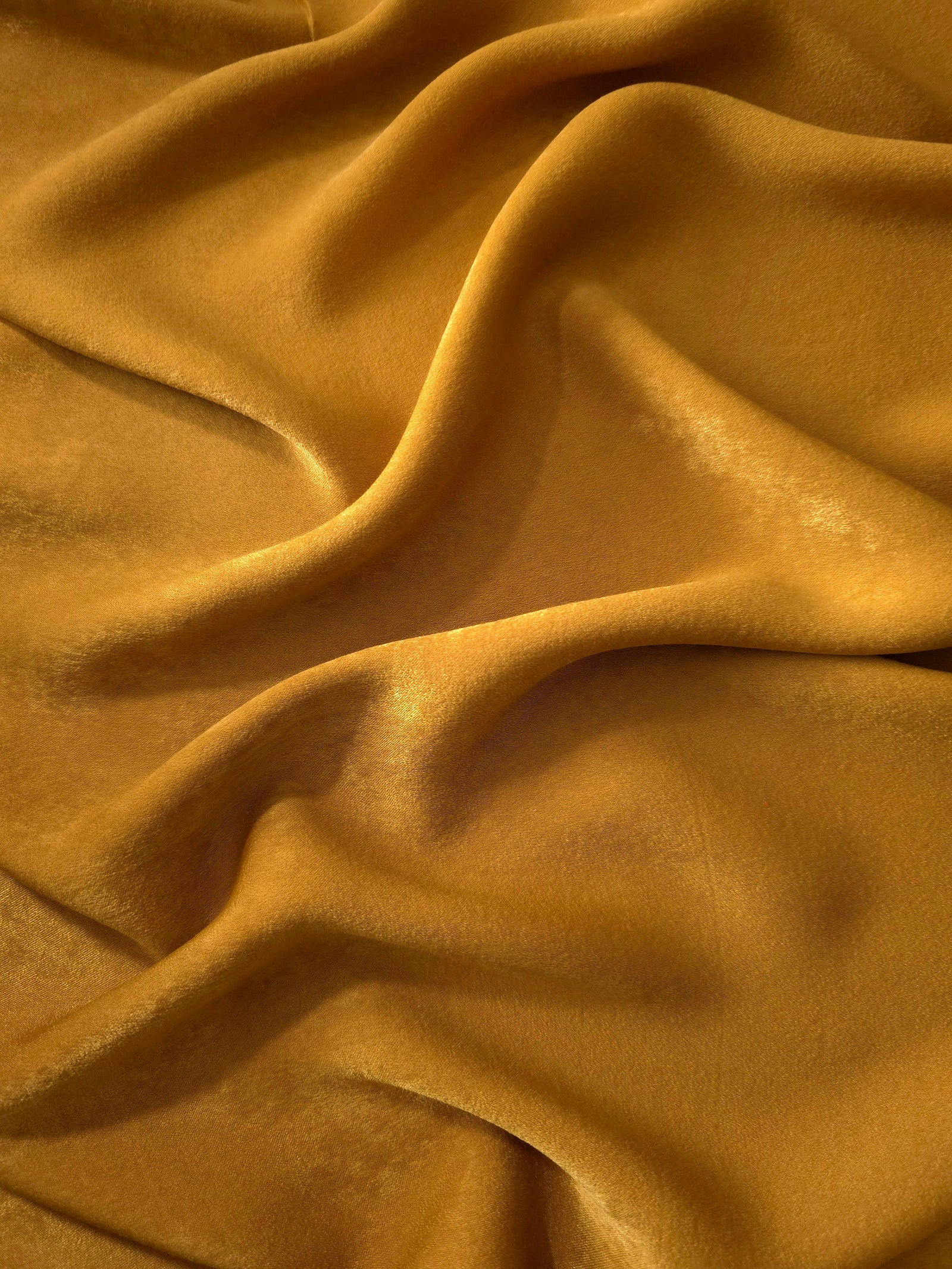 Matte silky sandwashed polyamide fabric in Golden Brown for dresses and apparel