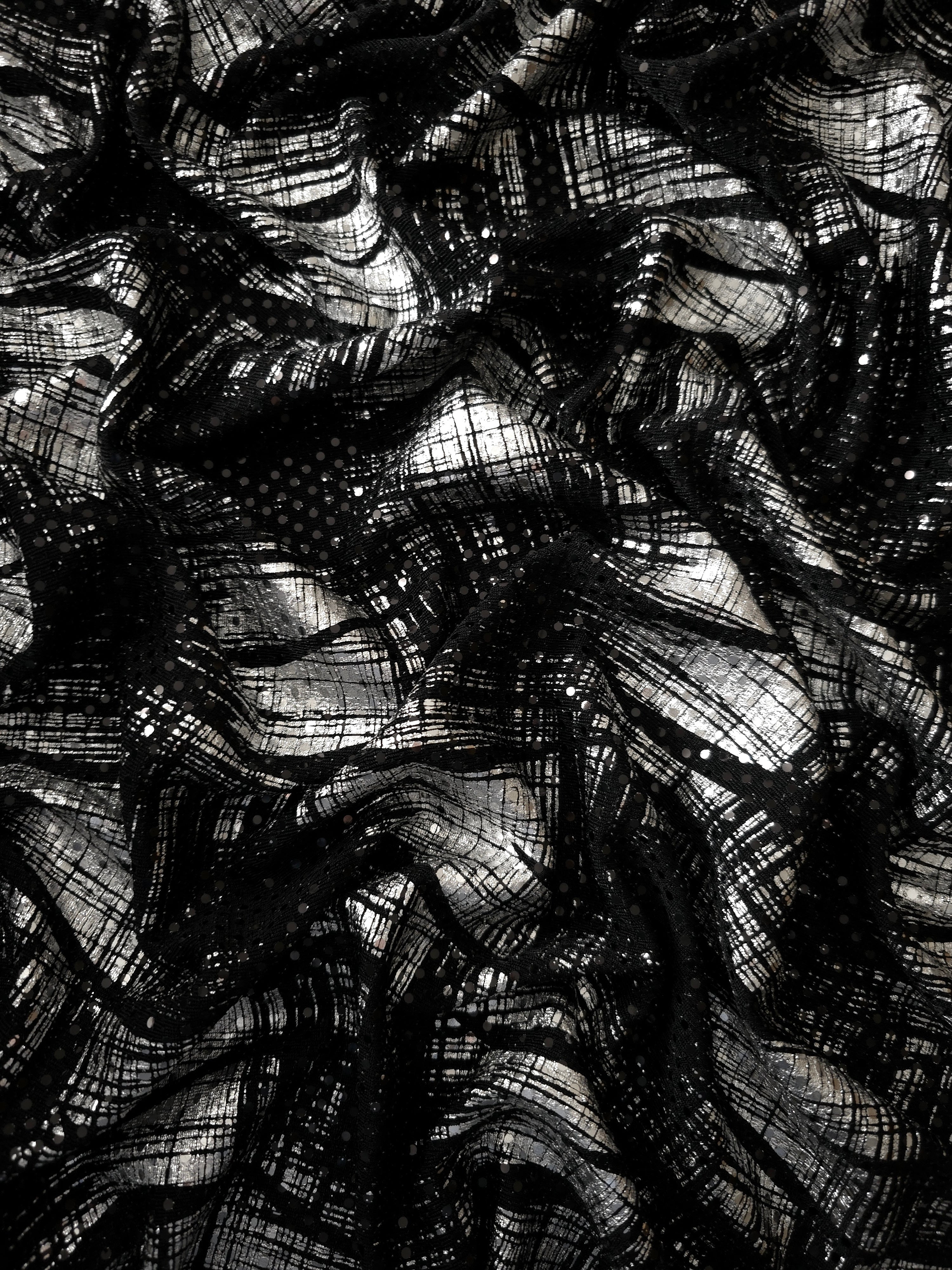 Flowing drape of Silver Gray Abstract Brush foil sequin fabric over a black mesh base, highlighting shimmer and fluid fall for prom dresses, cocktail looks and statement overlays.