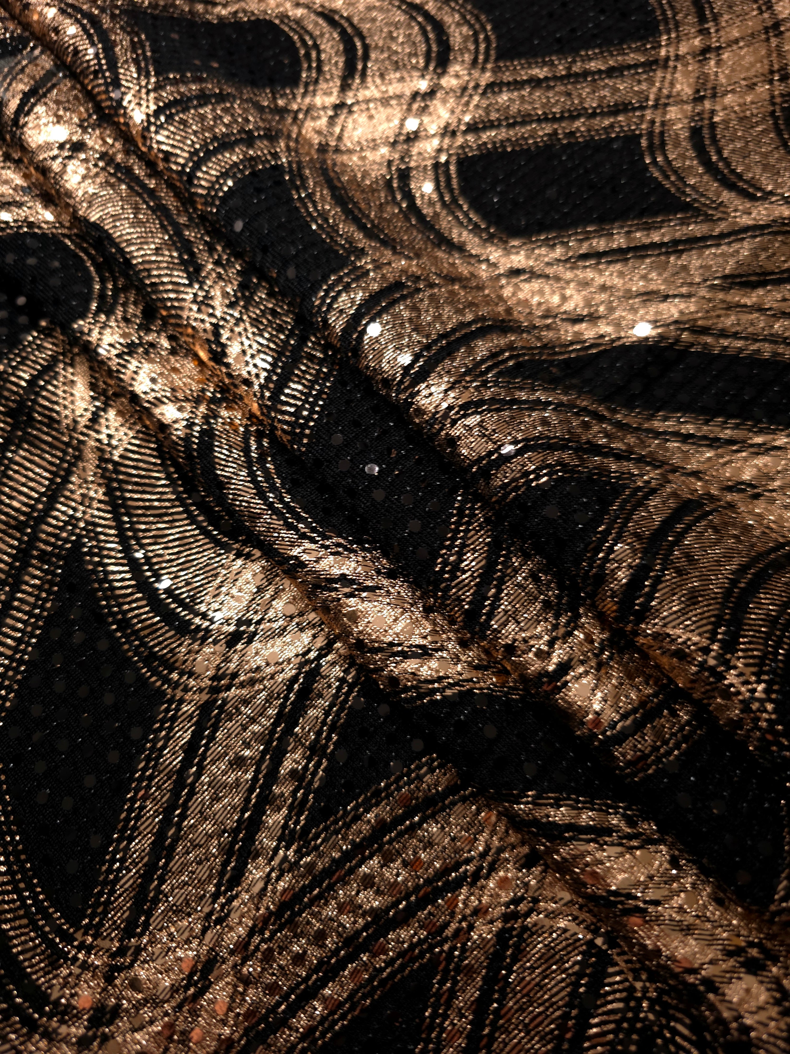 Soft folds of Rose Gold Fluid Waves metallic foil sequin fabric on black tulle create airy shimmer and gentle volume for evening gowns, formal skirts and stage costumes.