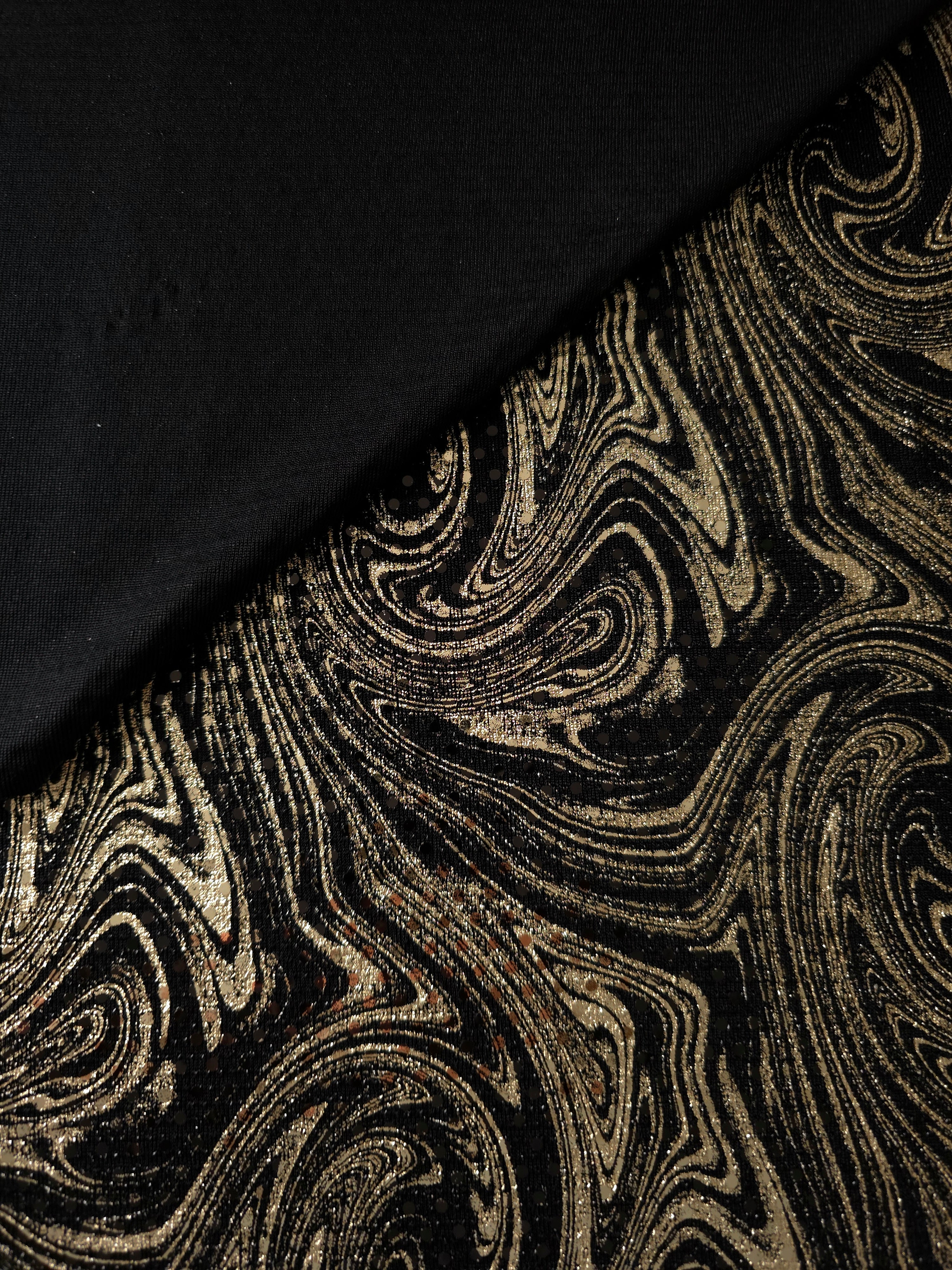 Fold detail of Soft Gold Marble Swirl metallic foil sequin fabric on black tulle, highlighting layered shimmer and surface depth for evening gowns, formal skirts and stage costumes.