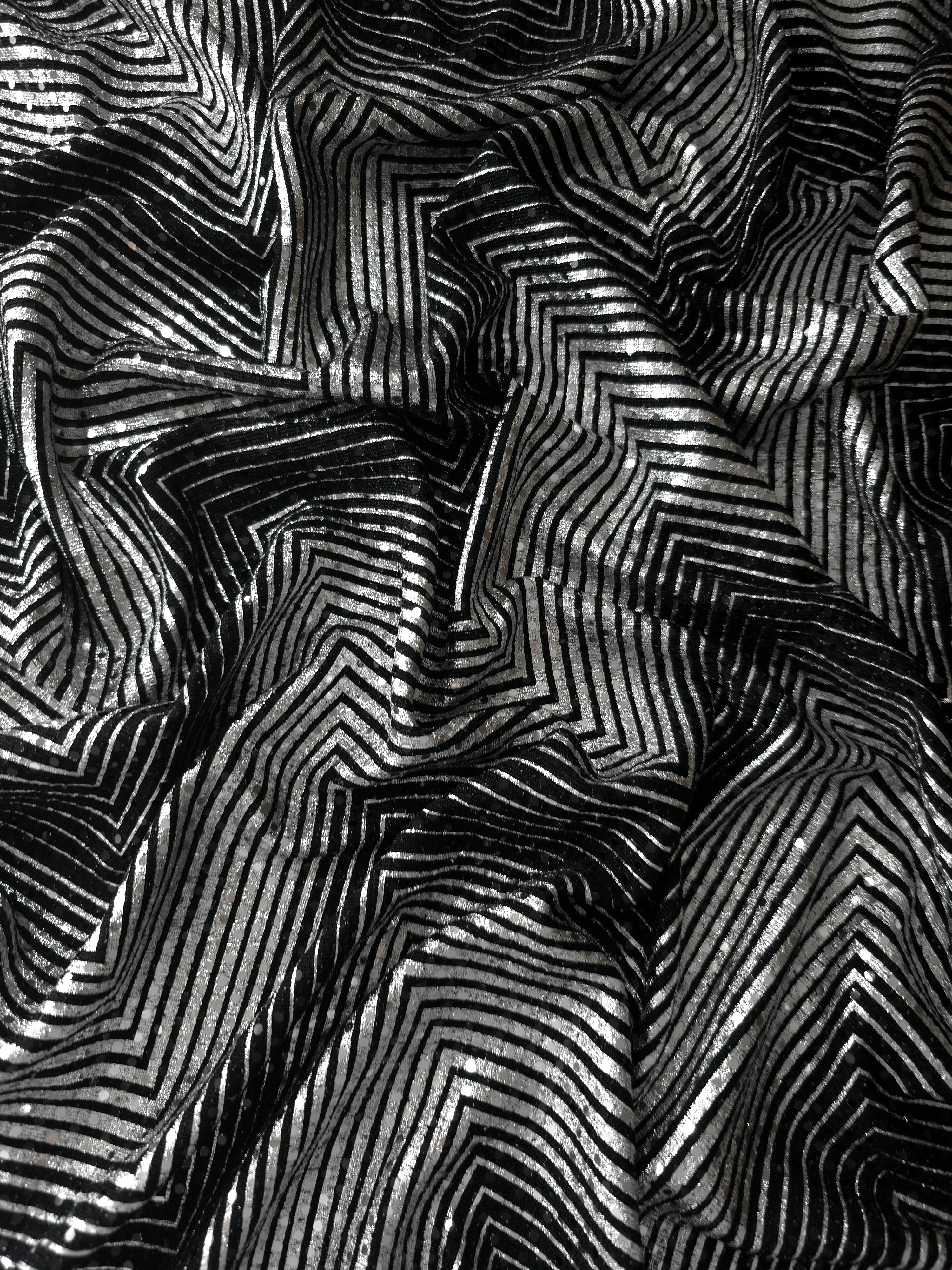 Draped view of Silver Gray Geometric Maze sequin fabric with metallic foil over black tulle, emphasizing graceful folds for prom gowns, statement sleeves and fashion accessories.