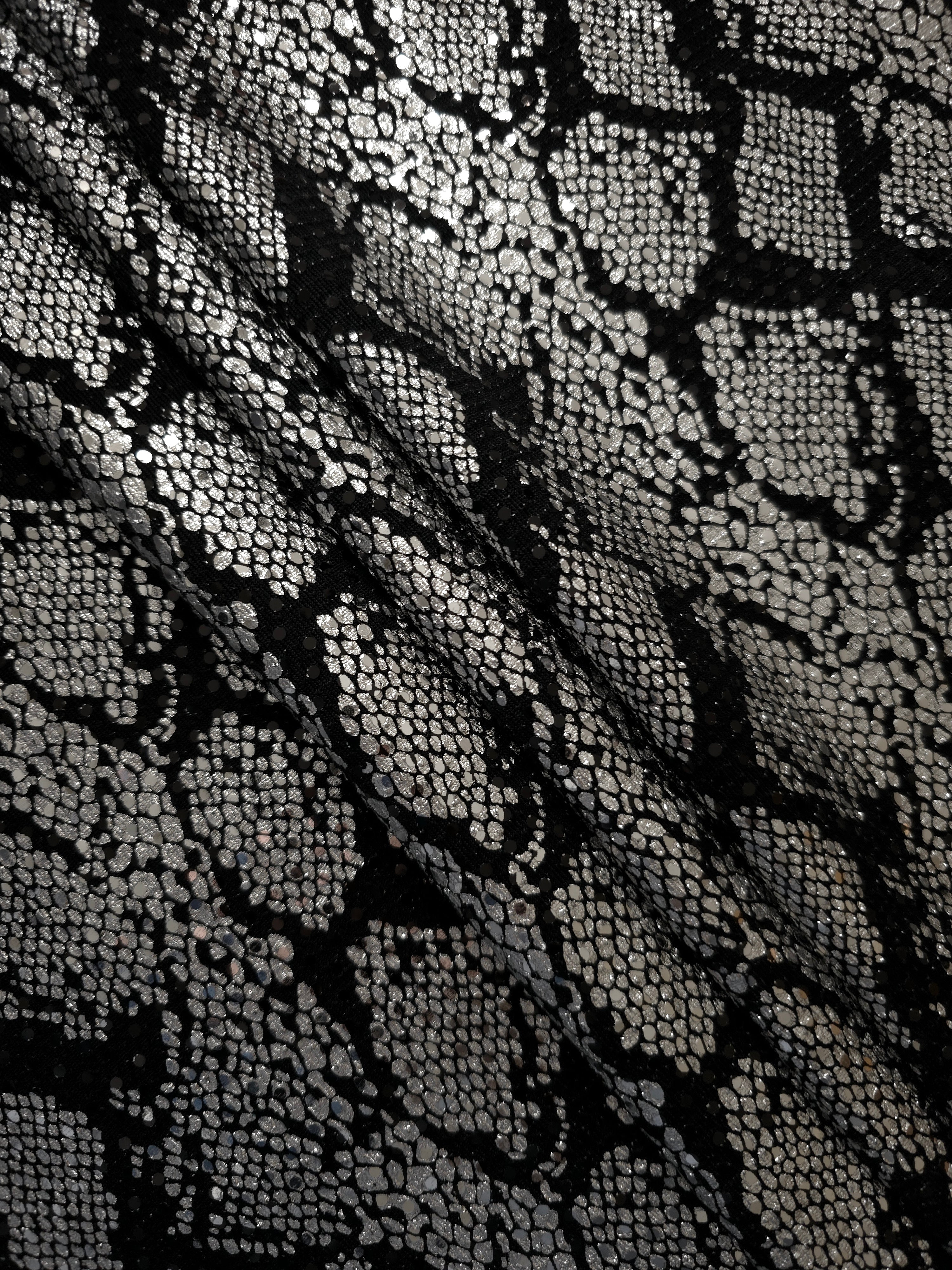 Soft folds of Silver Gray Metallic Python metallic foil sequin fabric on black tulle create airy shimmer and gentle volume for formal dresses, cape details and performance costumes.