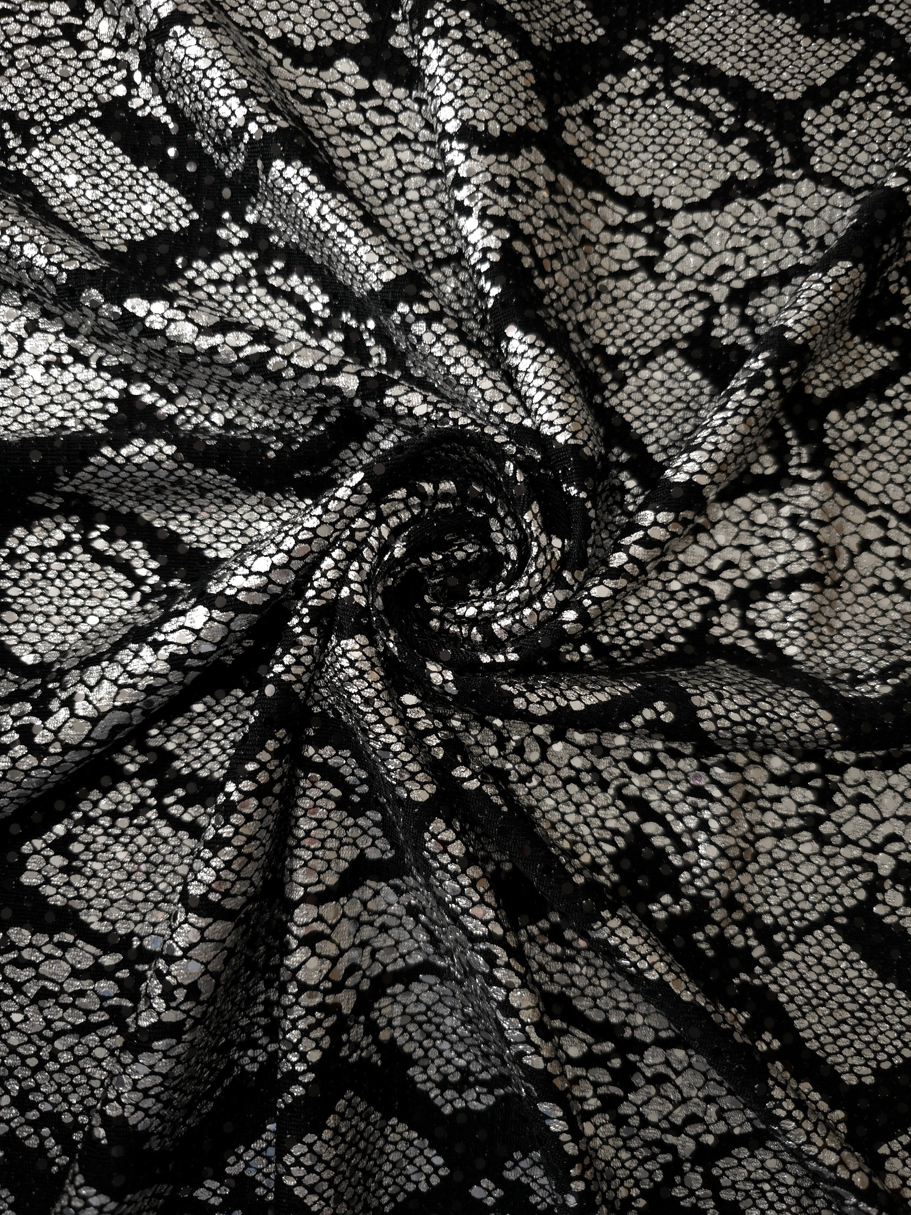 Twisted Silver Gray Metallic Python foil sequin fabric on black mesh demonstrates dimensional shine and graceful movement for prom gowns, statement sleeves and fashion accessories.