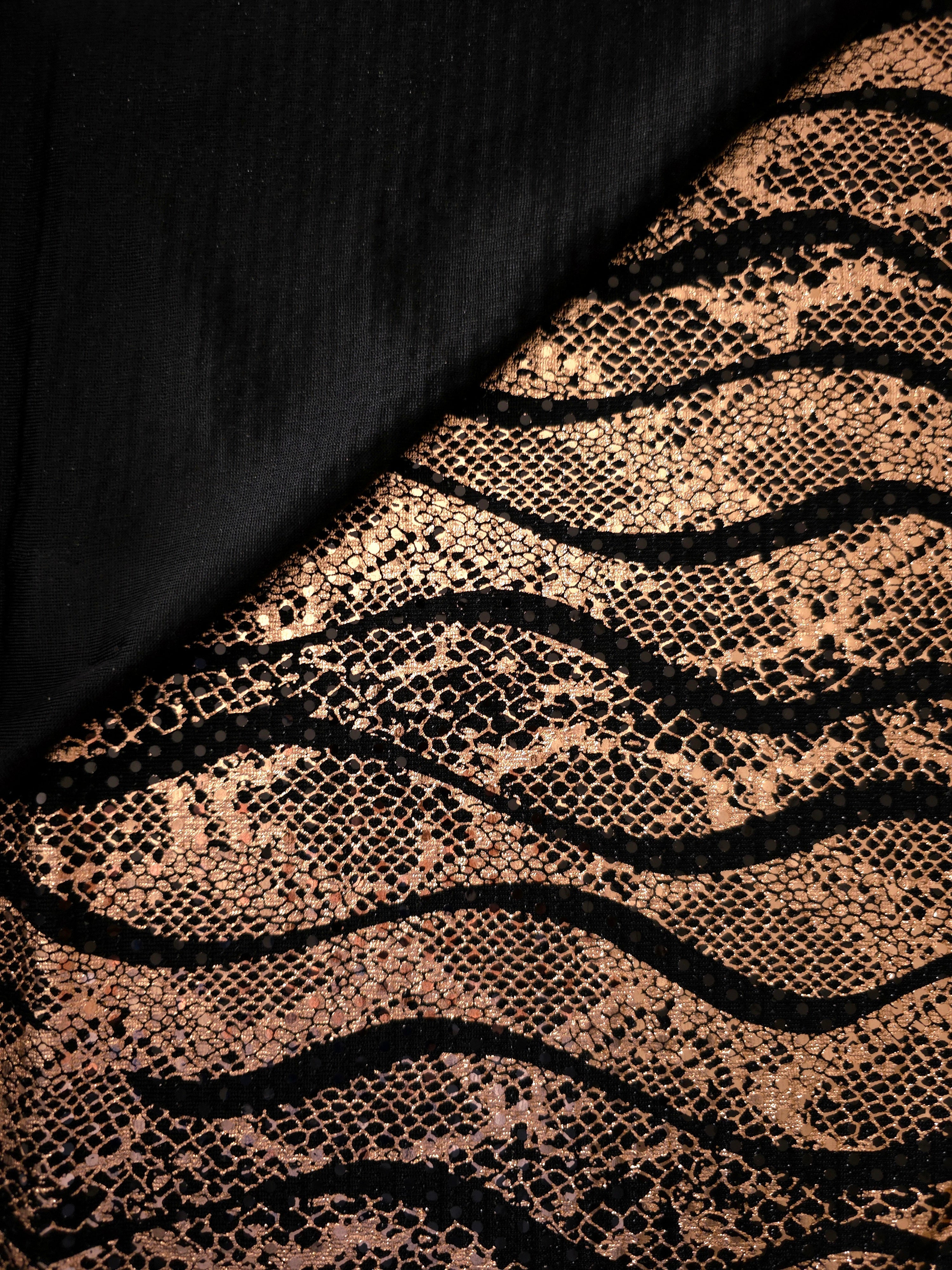 Close fold view of Rose Gold Wavy Python foil sequin mesh, showing how the reflective pattern gathers across black tulle for occasion skirts, bodice panels and stagewear.