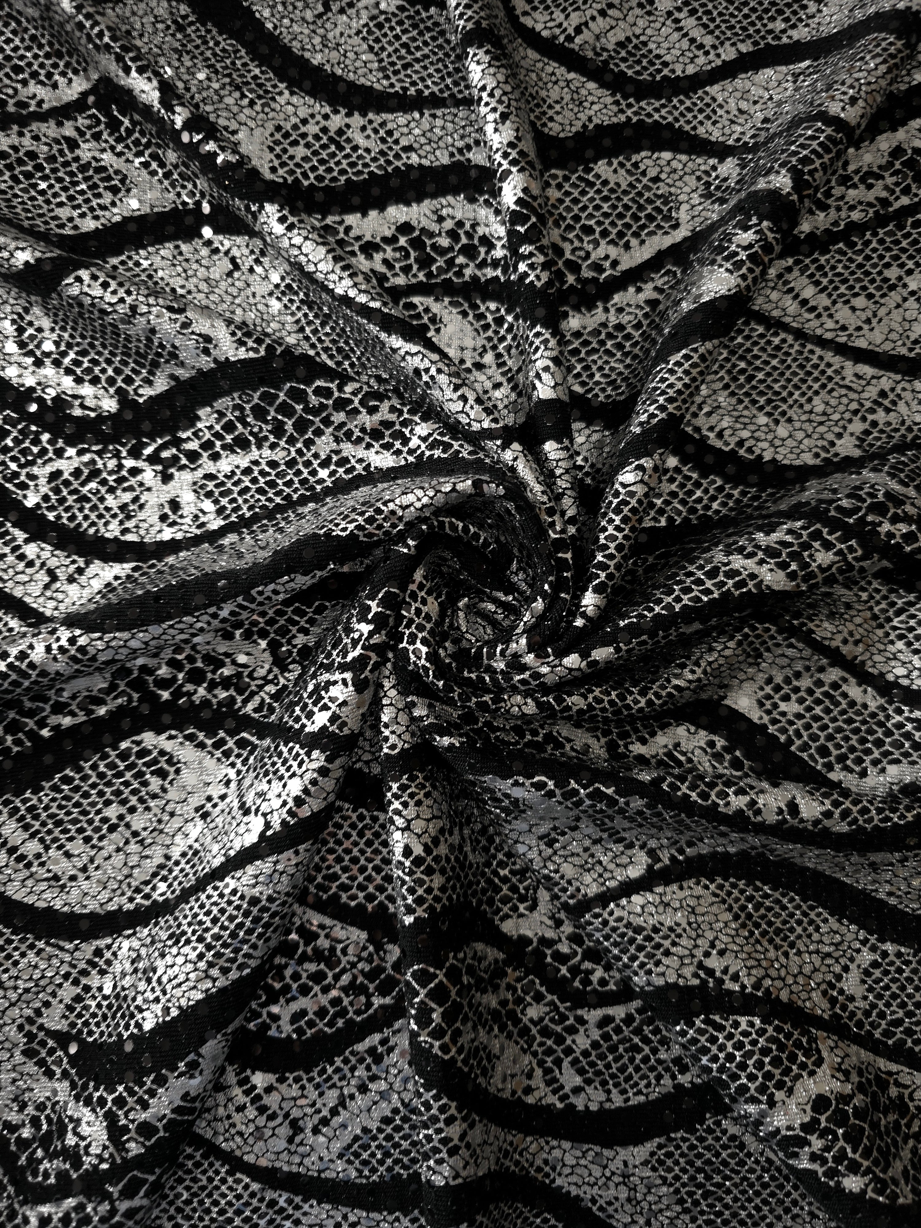 Sculpted twist of Silver Gray Wavy Python sequin fabric reveals metallic highlights and flowing black tulle underneath for special-occasion garments, performance pieces and overlays.