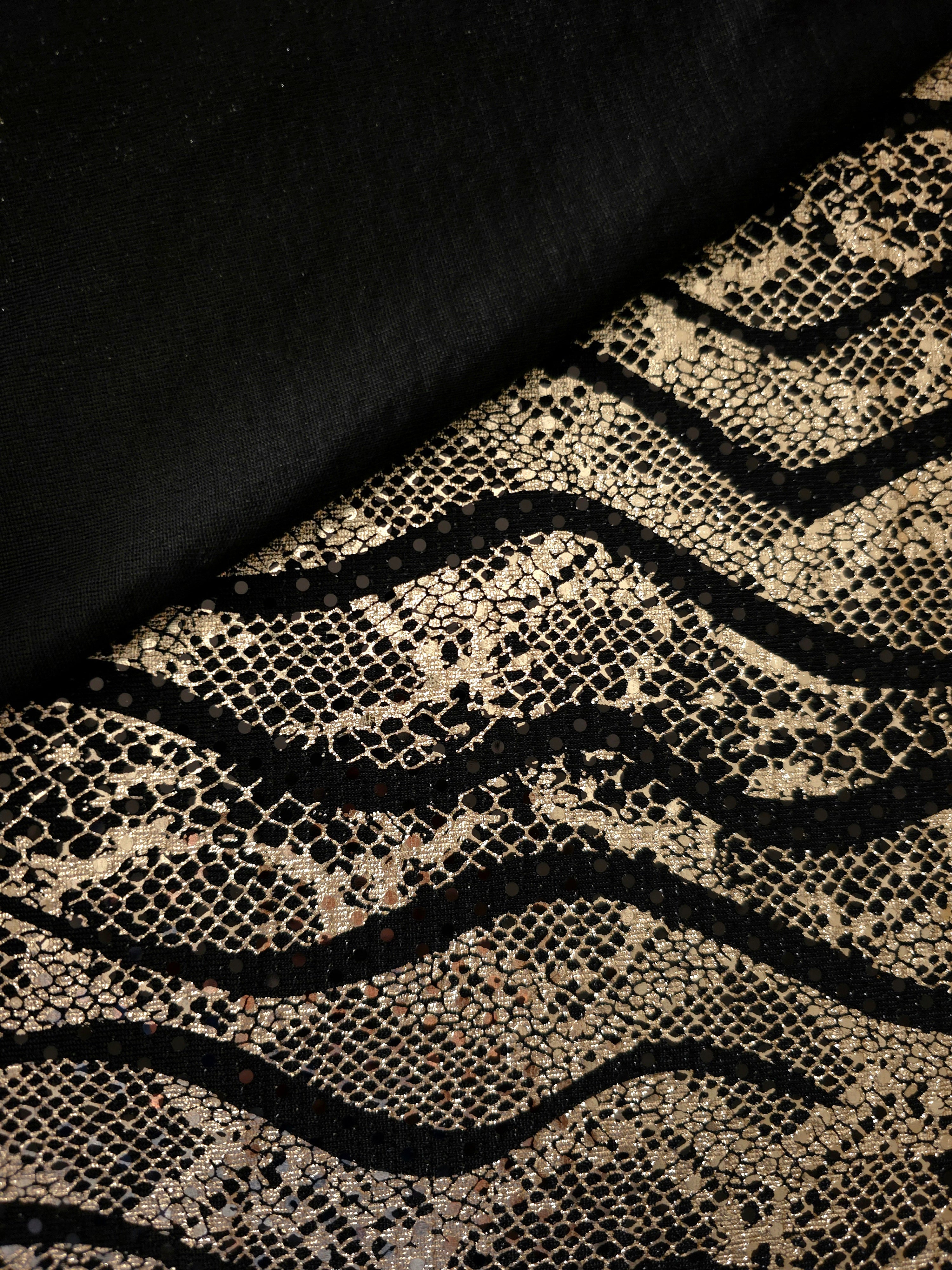 Close fold view of Soft Gold Wavy Python foil sequin mesh, showing how the reflective pattern gathers across black tulle for occasion skirts, bodice panels and stagewear.