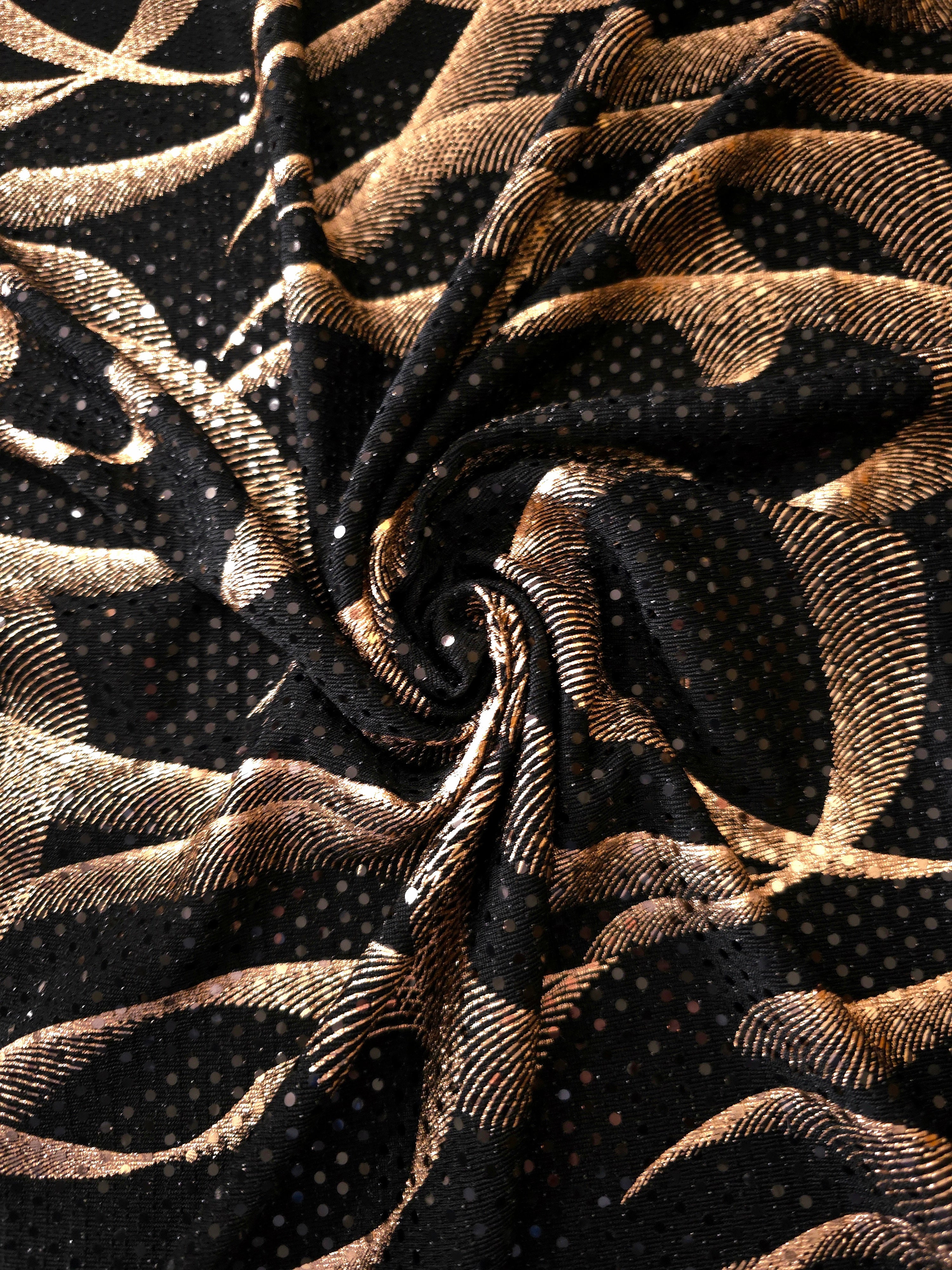 Twisted drape of Rose Gold Abstract Ribbon metallic foil sequin fabric, emphasizing light-catching movement over black tulle for formal dresses, cape details and performance costumes.